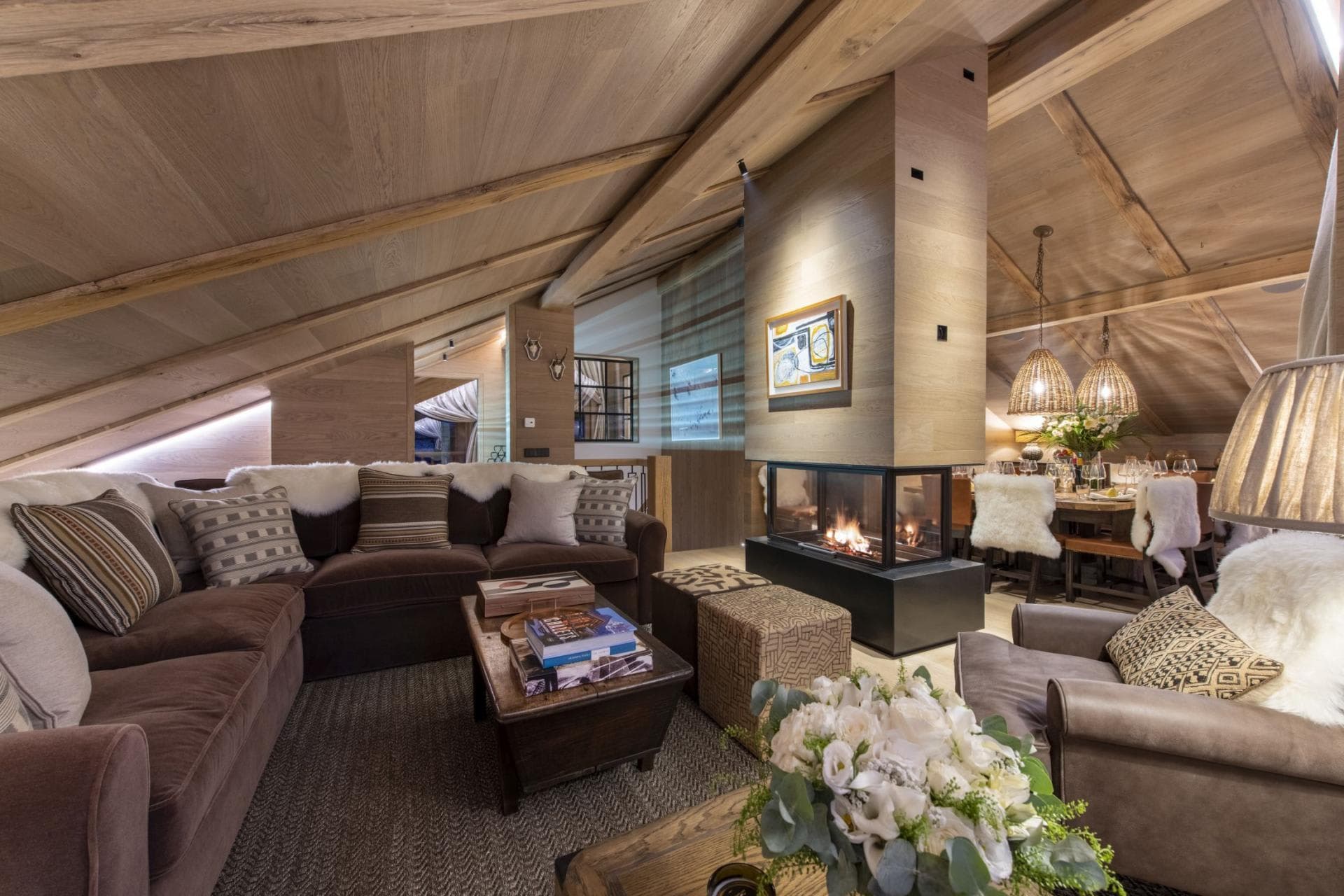 Open living area with three-sided fireplace and vaulted wood ceilings