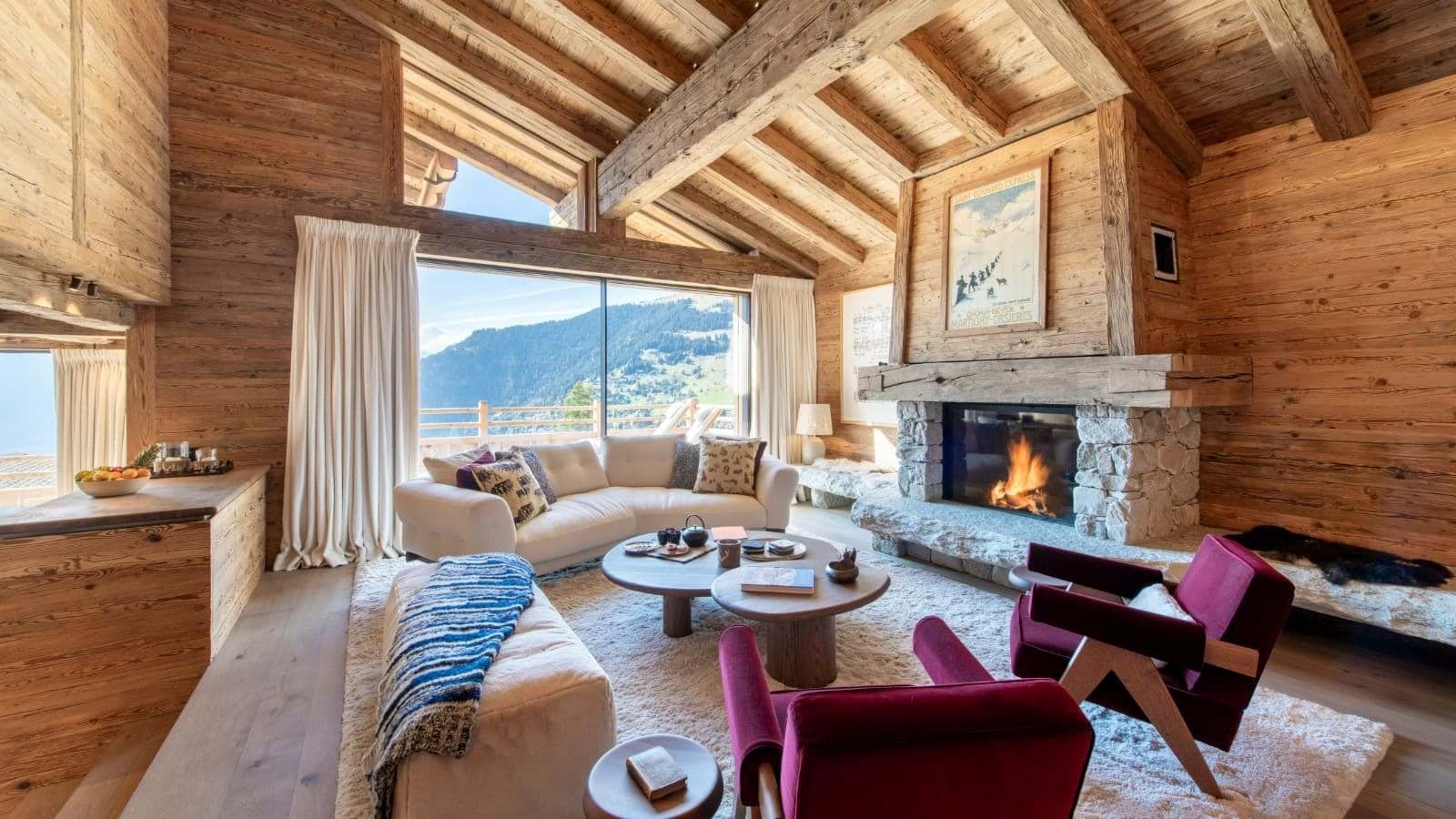 Living room with wood-burning stone fireplace and mountain views