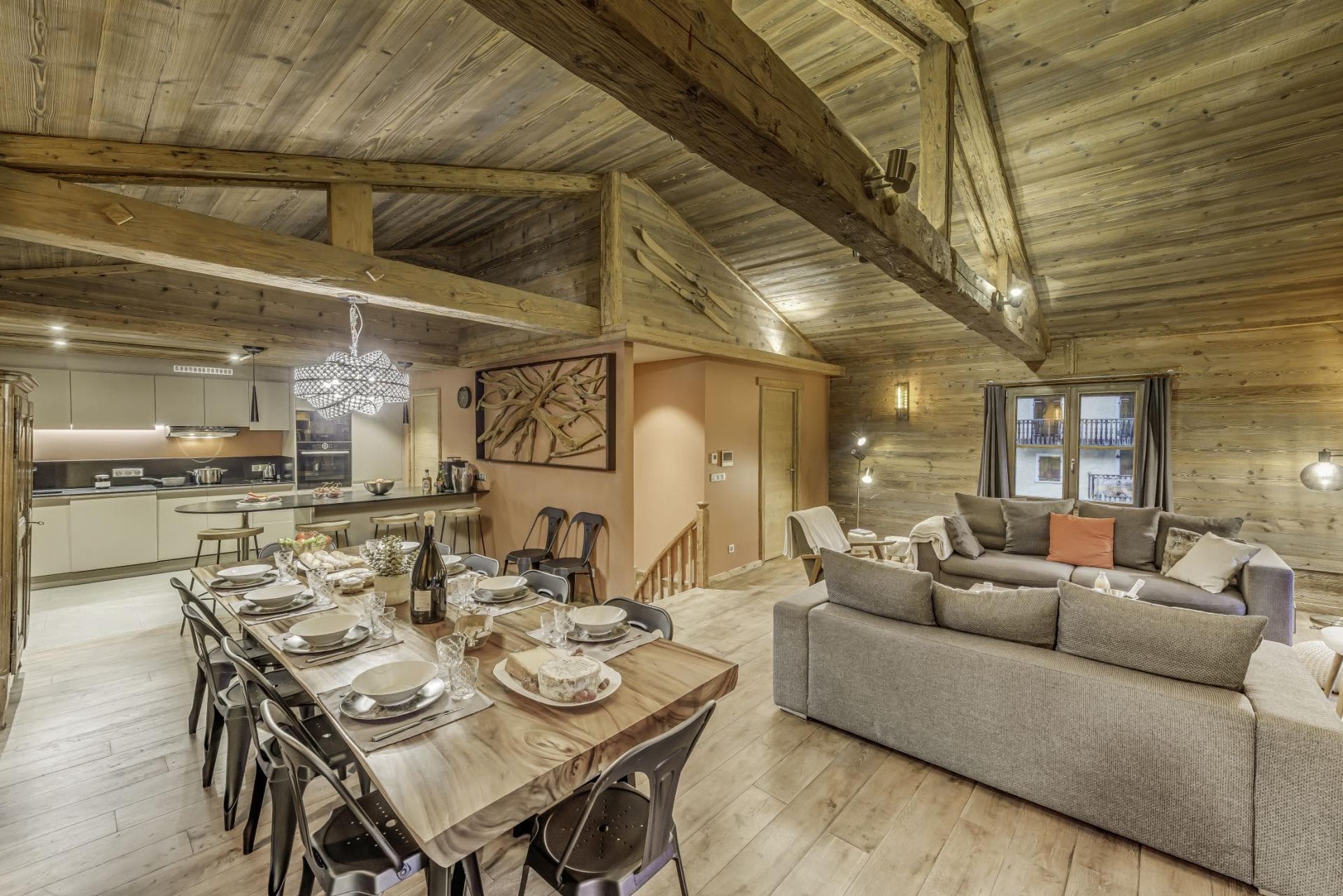 Open-plan living area under vaulted timber ceilings; dining table seats 10