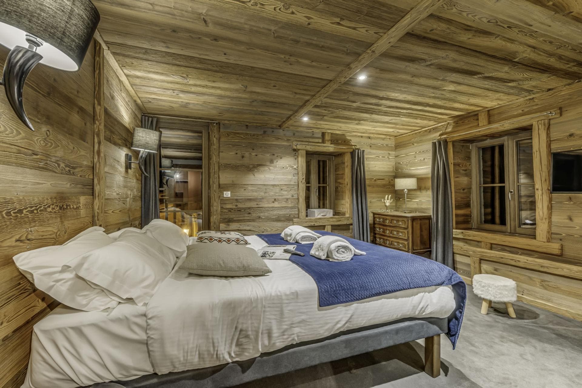 Wood-paneled bedroom with king bed and reclaimed timber walls