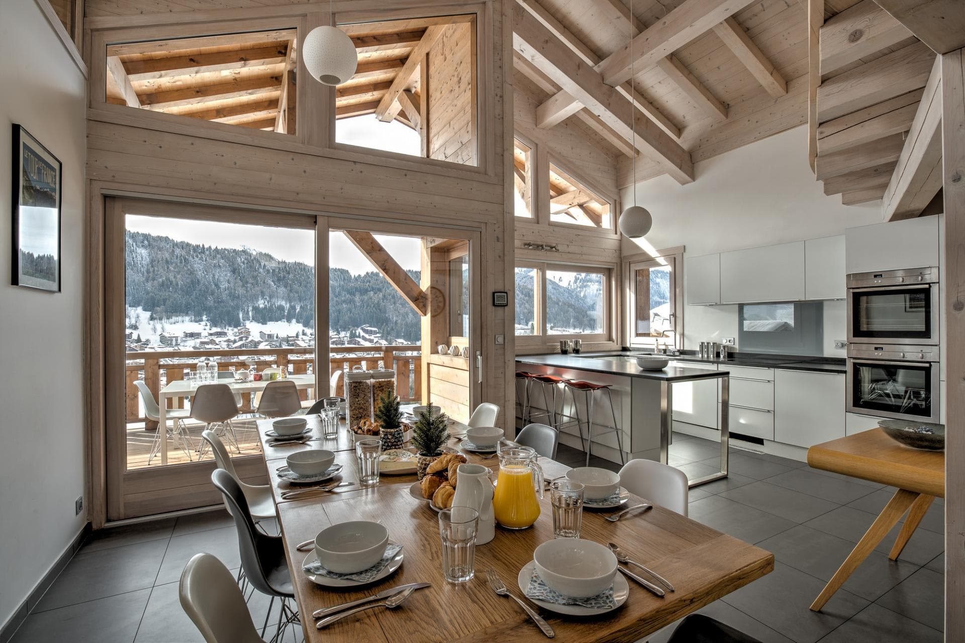 Open-concept kitchen and dining area with double ovens and mountain-view balcony