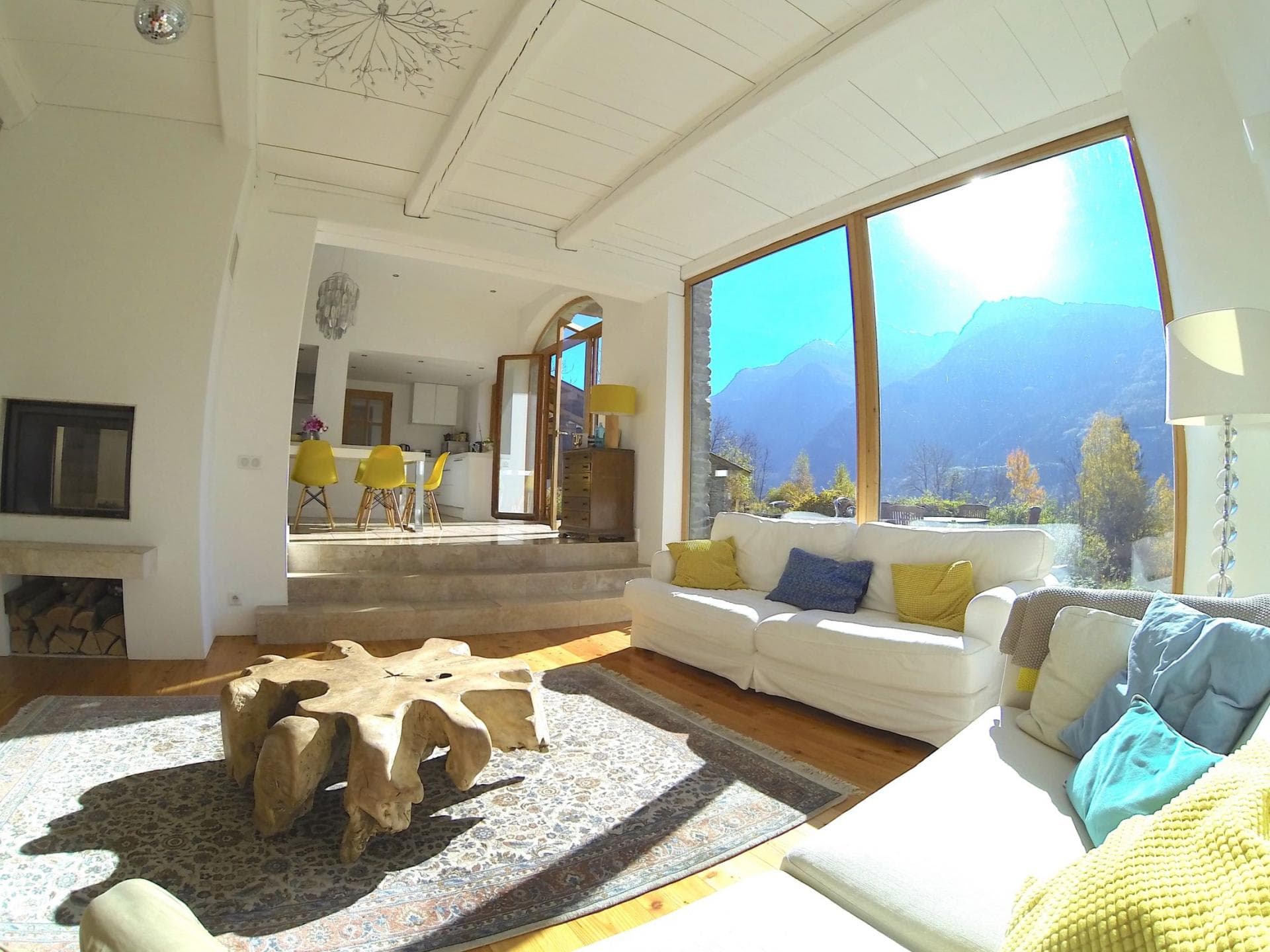 Sunken living room with wood-burning fireplace and floor-to-ceiling mountain views