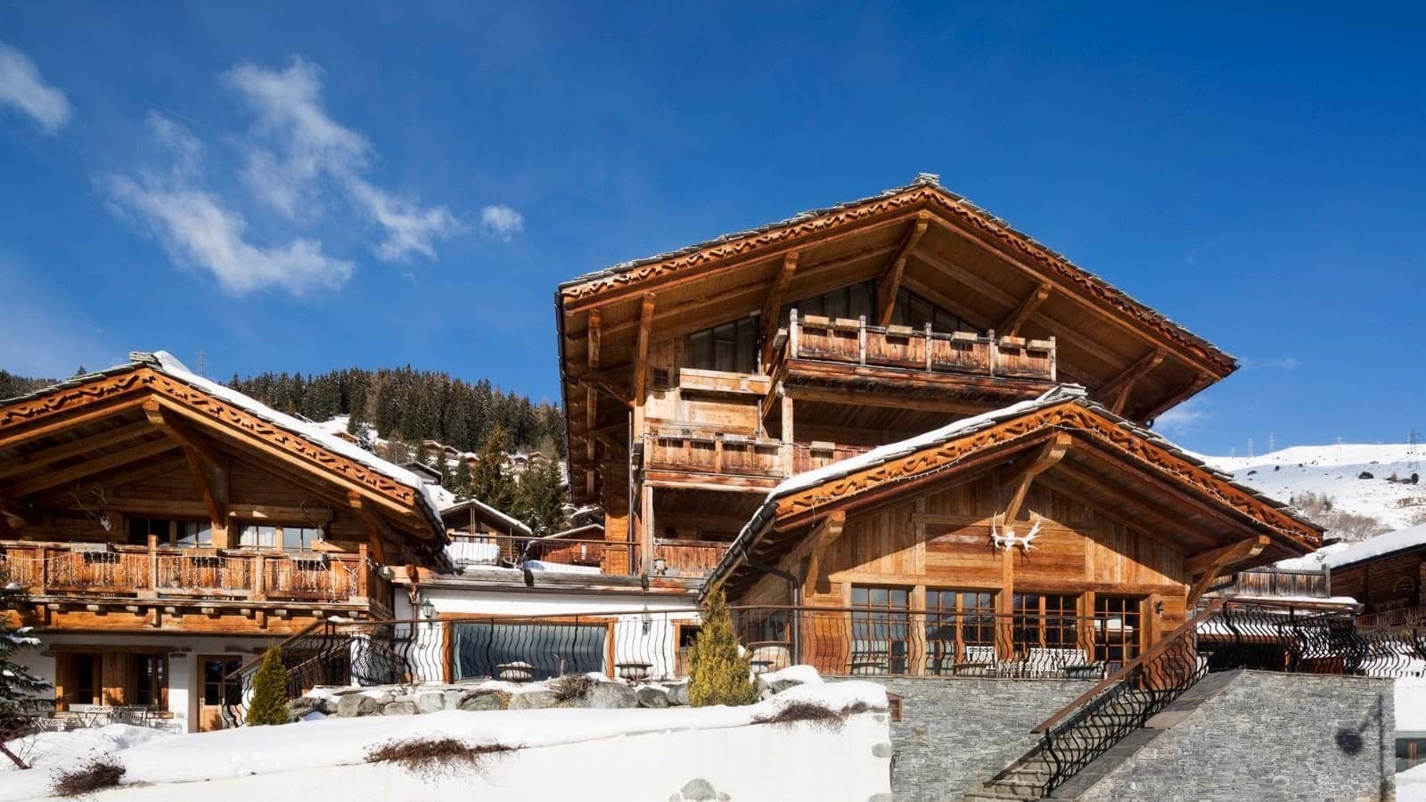 Chalet exterior with multiple private balconies and stone terrace