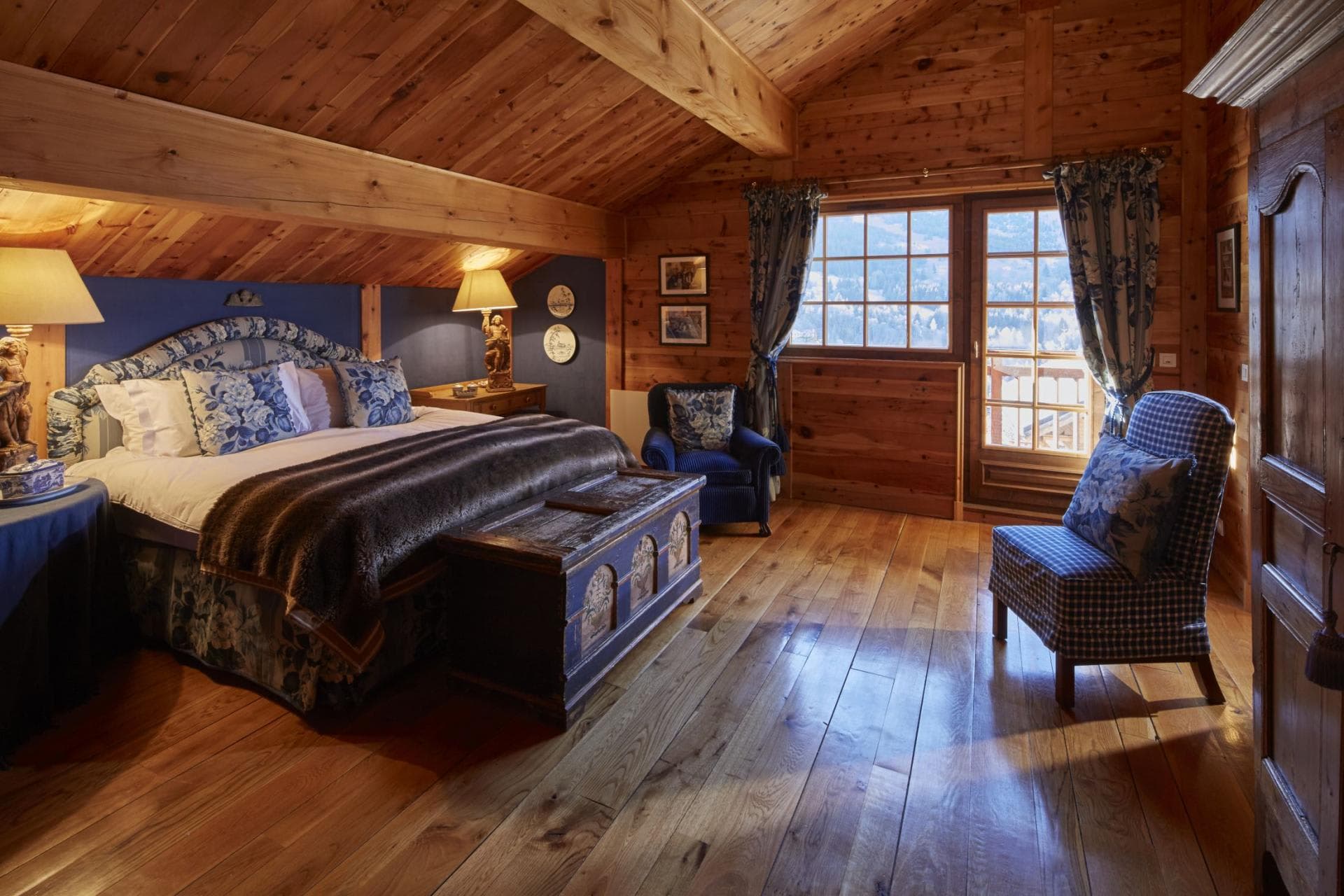 Wood-paneled bedroom with king bed and private balcony access