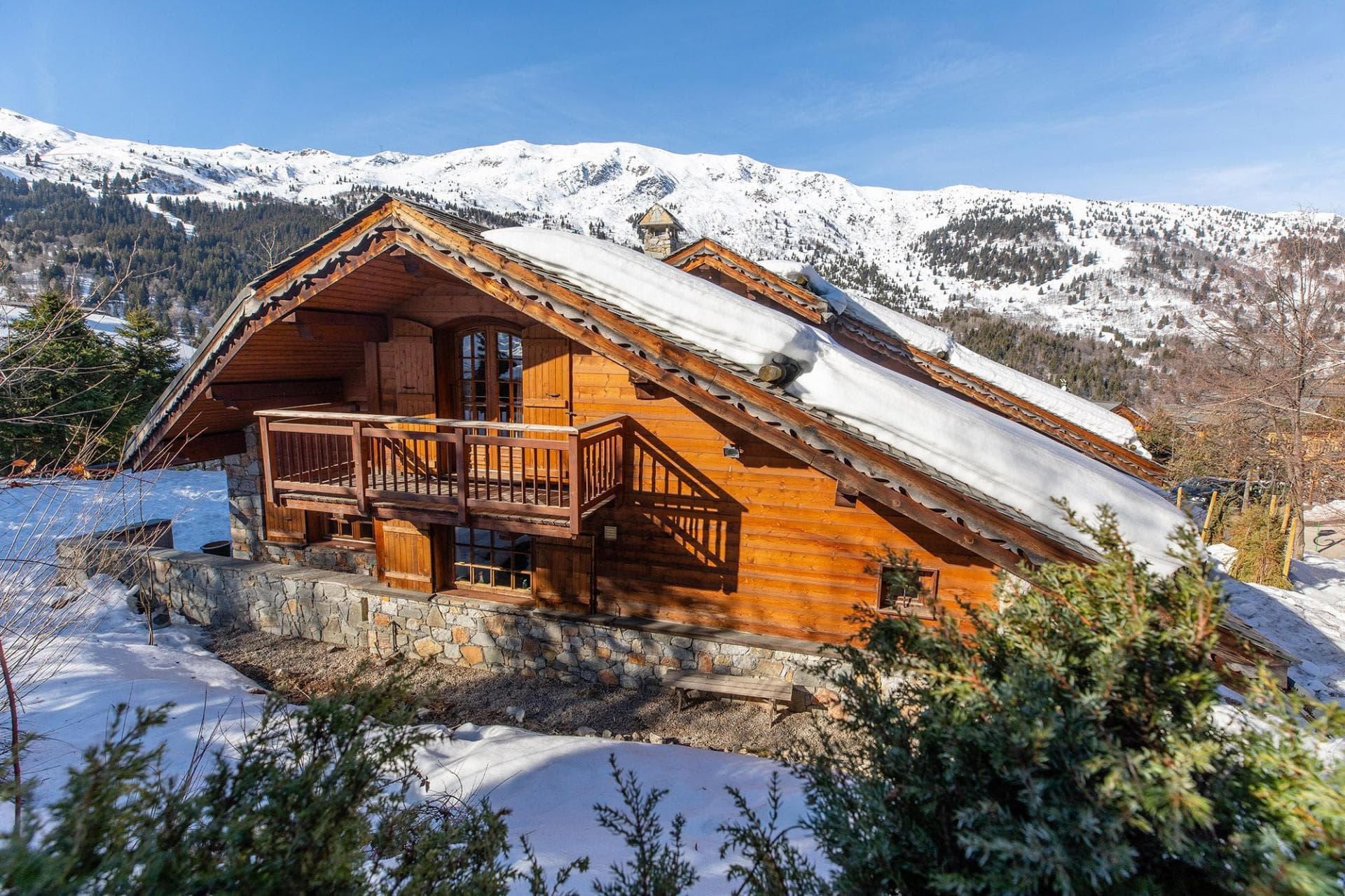 Ski-in chalet exterior with private balcony and alpine mountain views