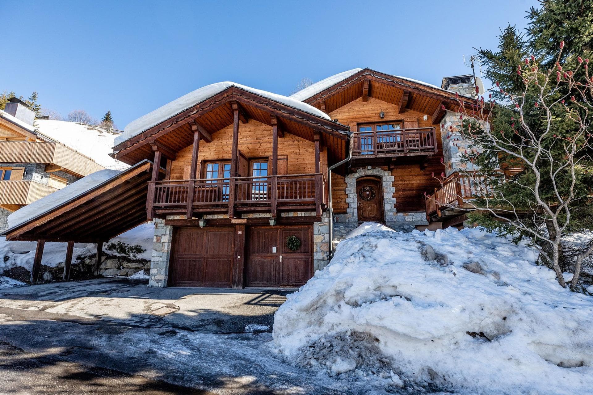 Chalet exterior with two-car garage and covered parking port
