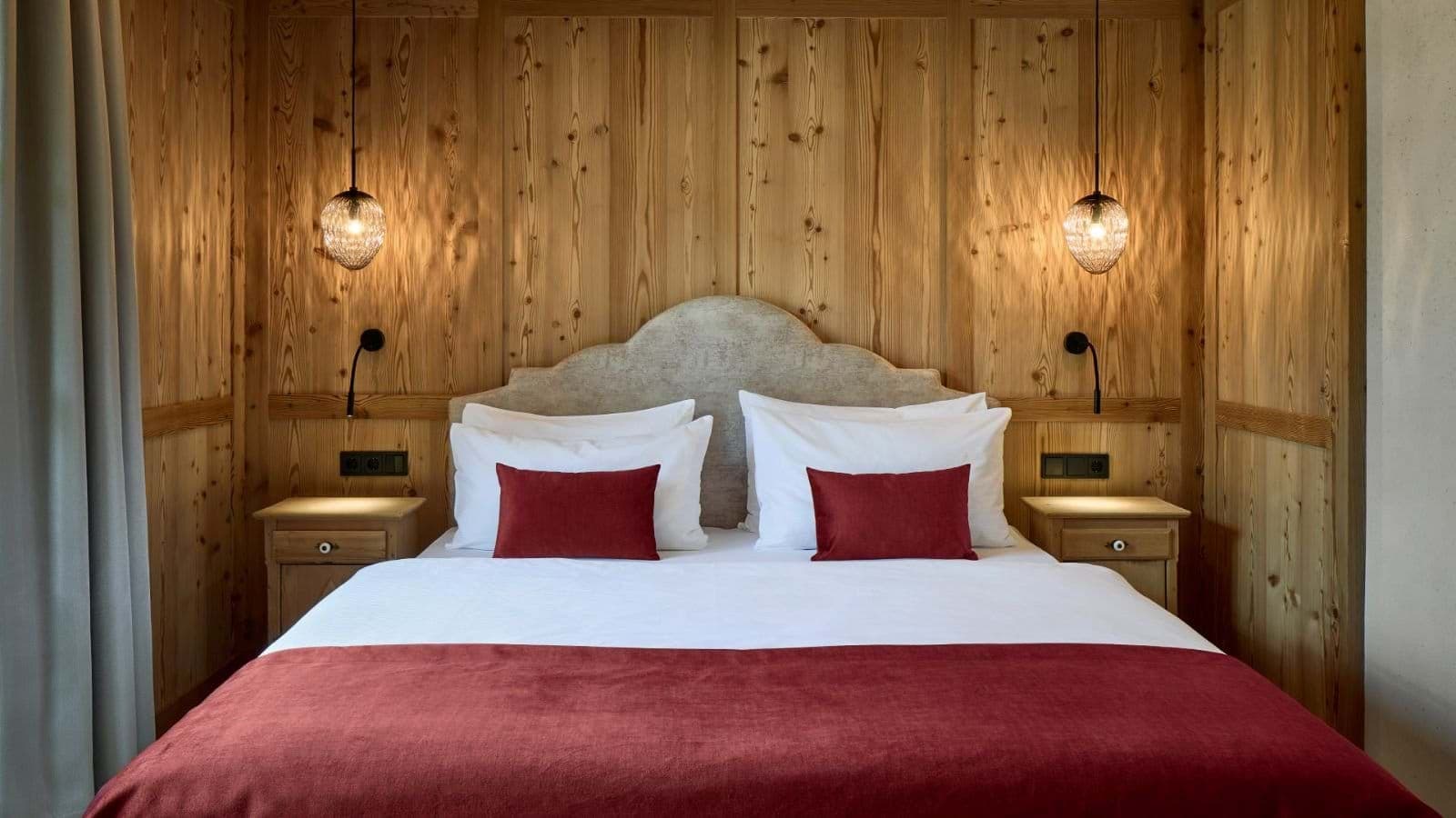 Bedroom with pine paneling, king bed, and integrated bedside reading lights