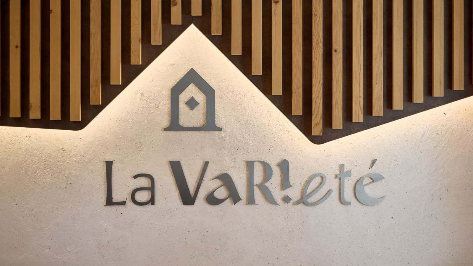 Property branding wall with back-lit logo and timber slat accents