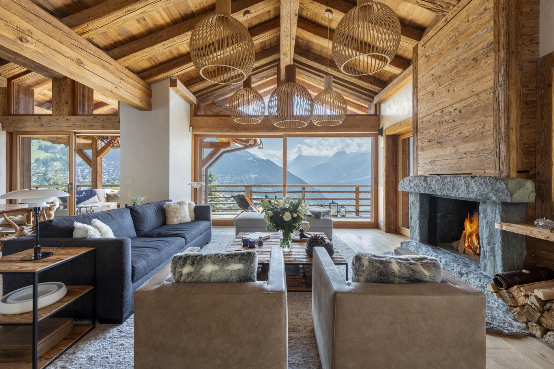 Living area with wood-burning fireplace and floor-to-ceiling mountain views