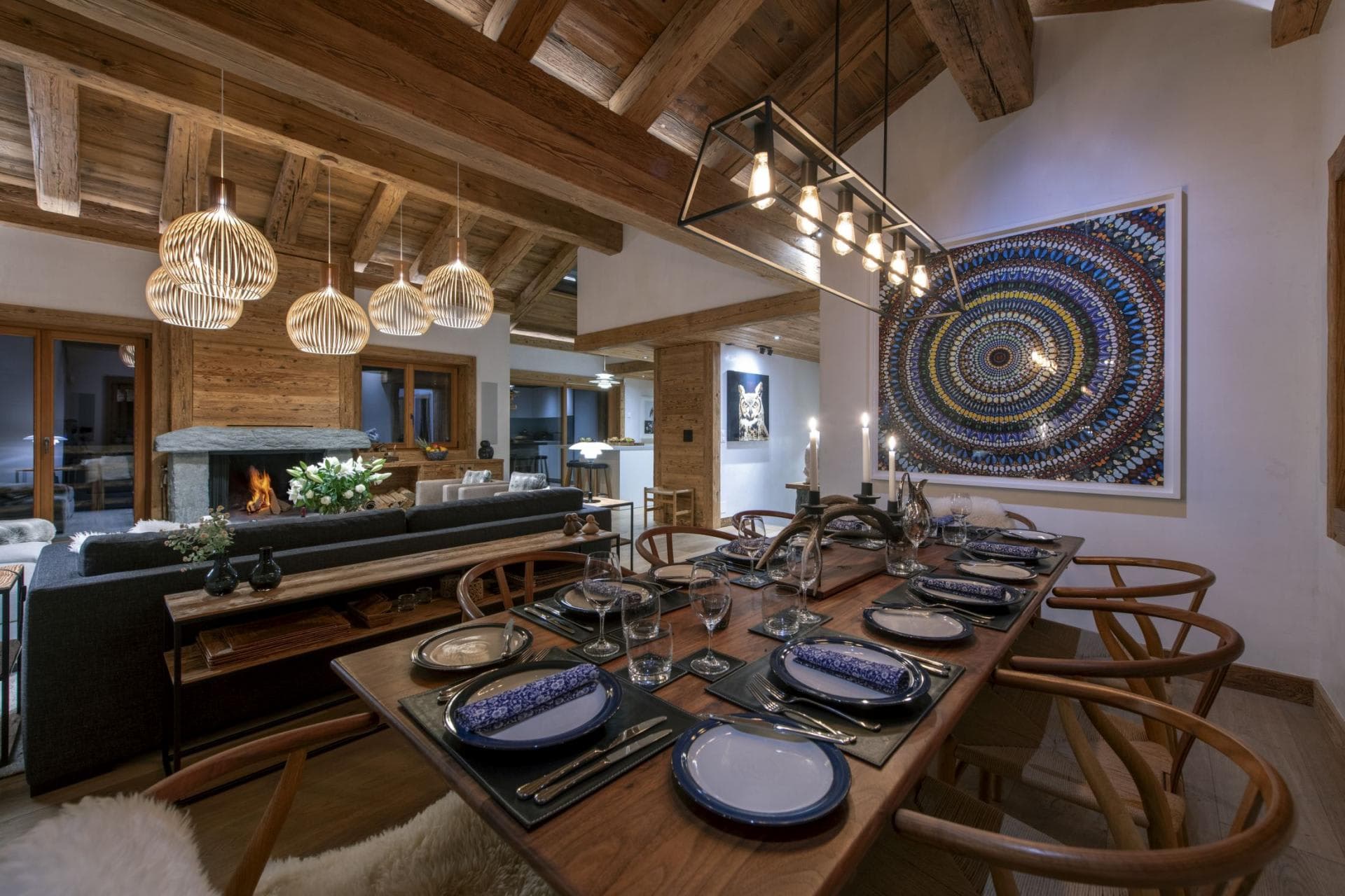 Open-plan dining area seating 10 with wood-burning fireplace and exposed timber beams