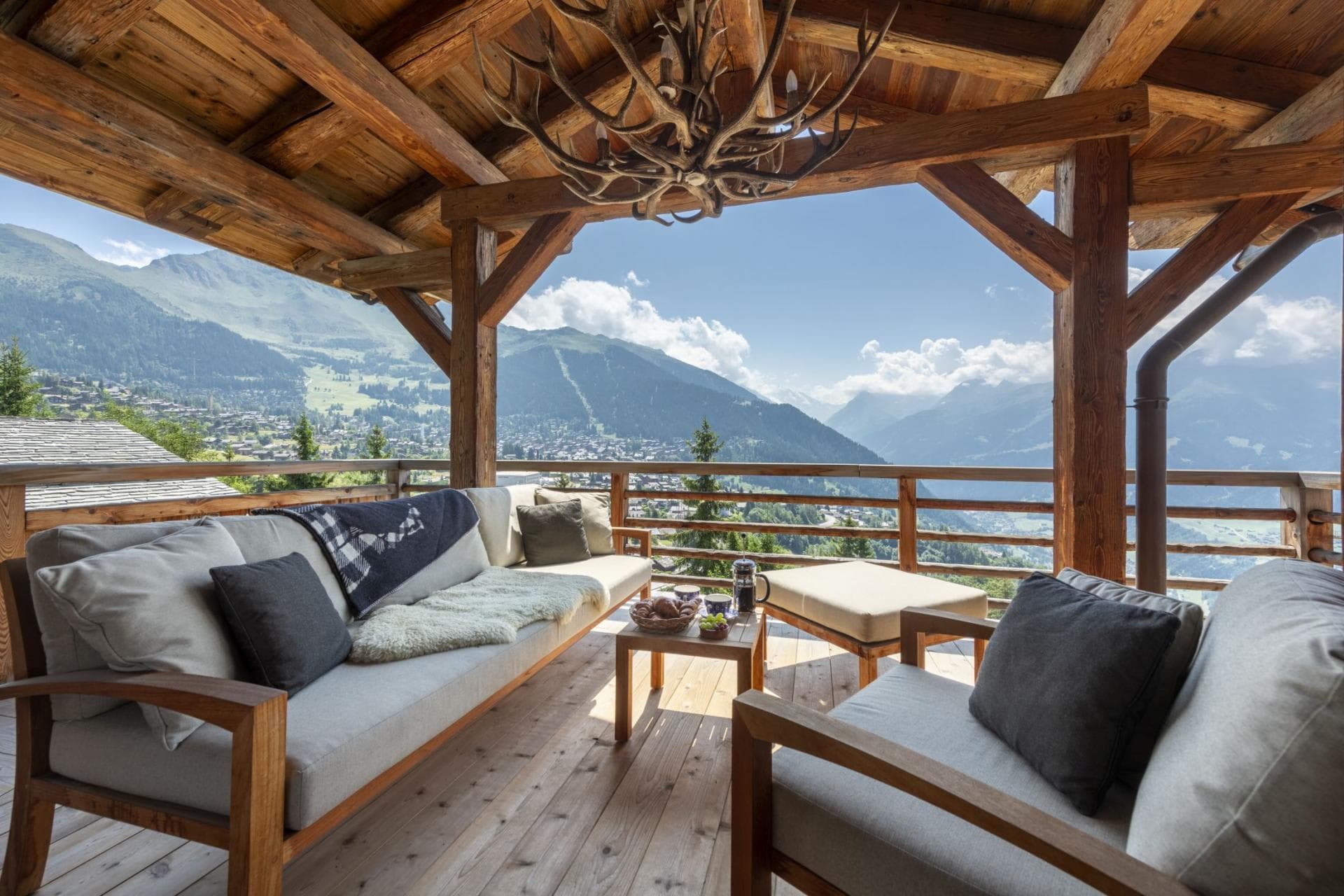 Covered balcony with lounge seating and panoramic alpine valley views