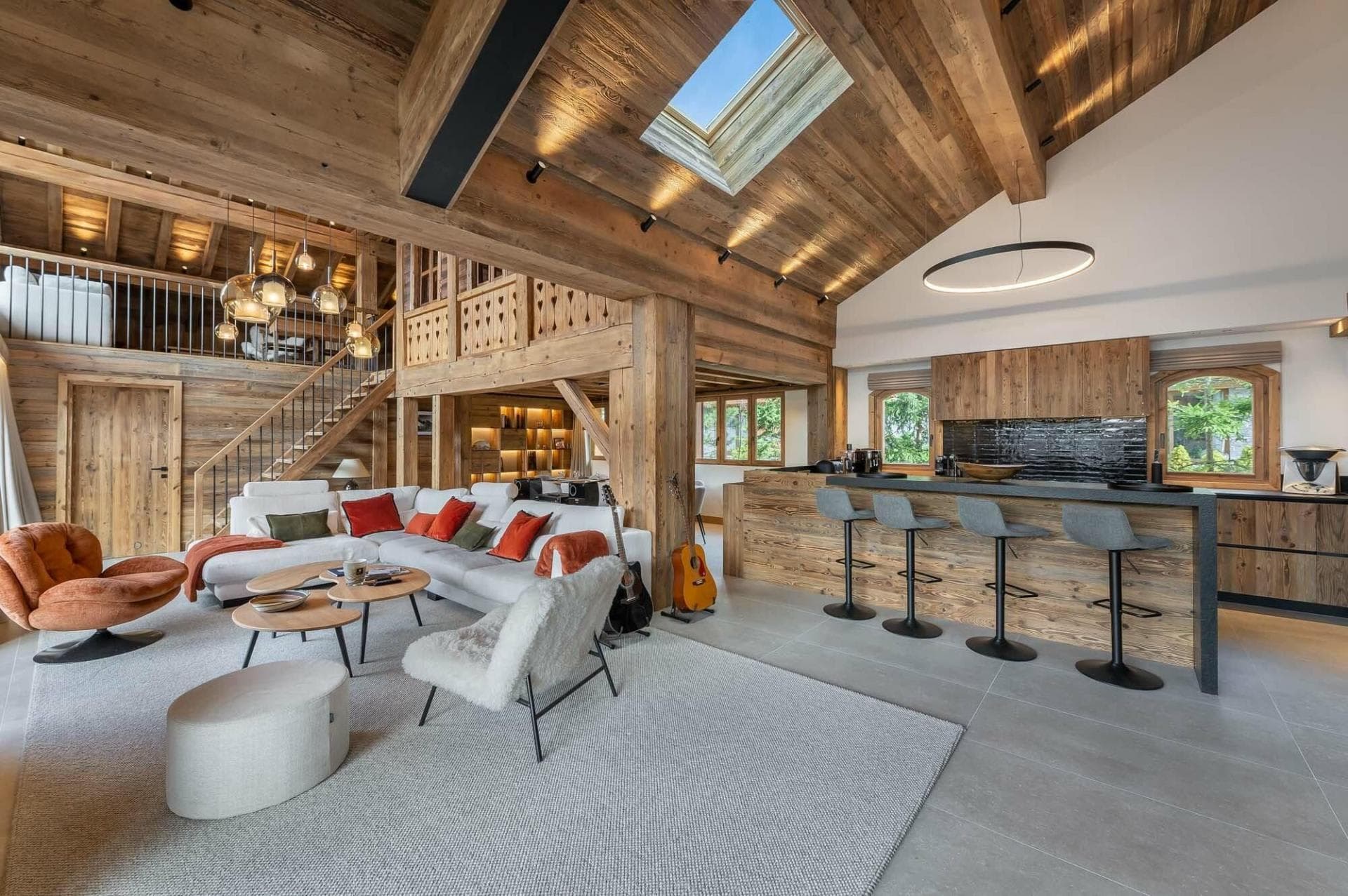 Open living area with vaulted ceilings, skylight, and breakfast bar seating 4