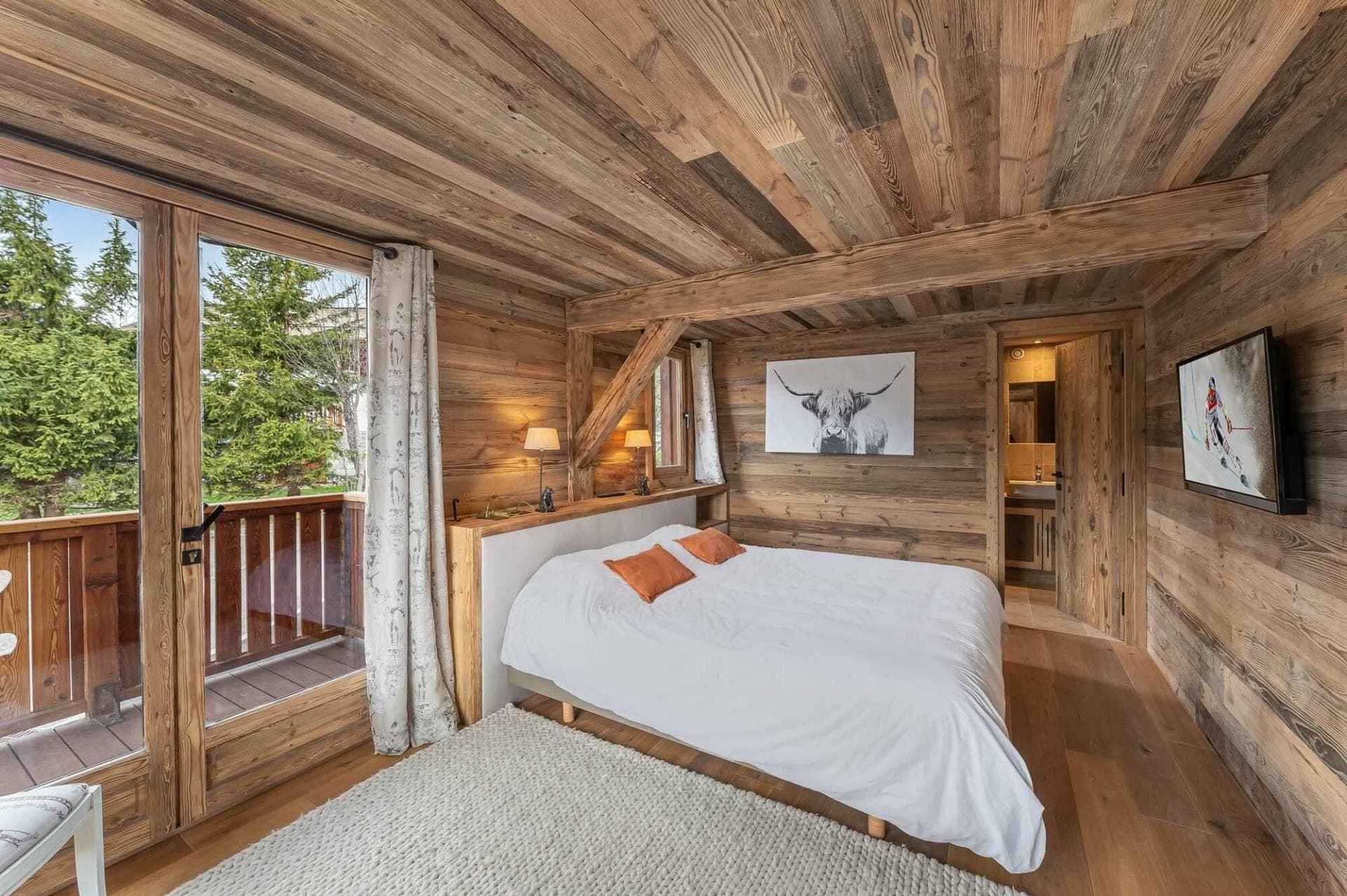 Wood-paneled bedroom with private balcony access and ensuite bathroom