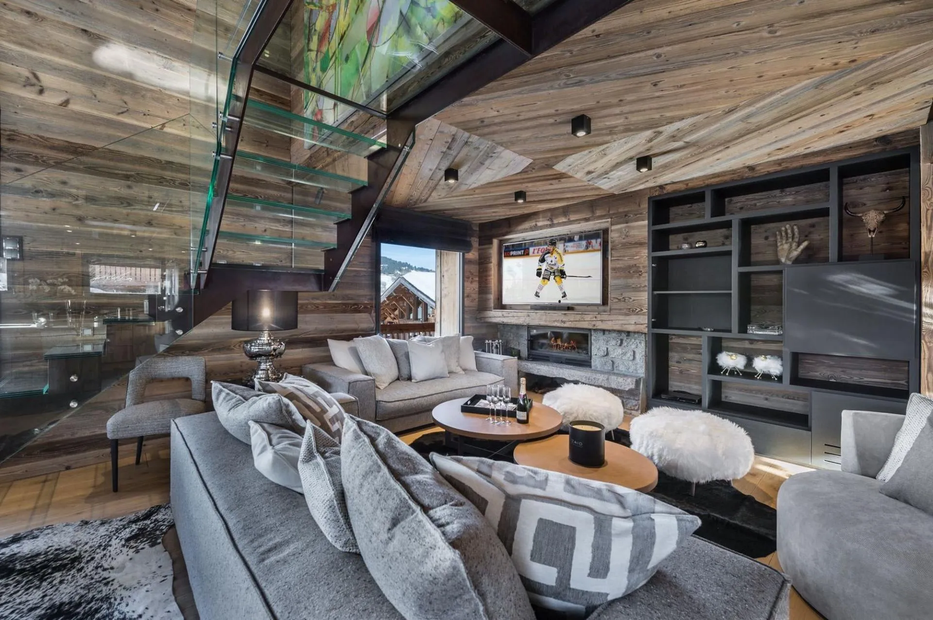 Sofas and fireplace beside the glass staircase