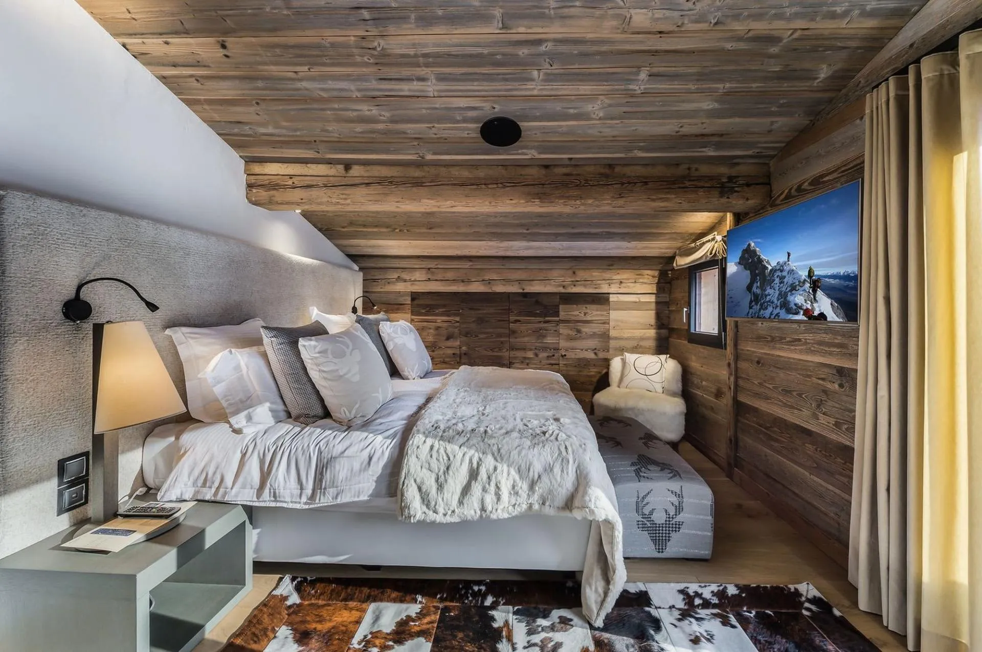 Double bedroom with timber walls and television