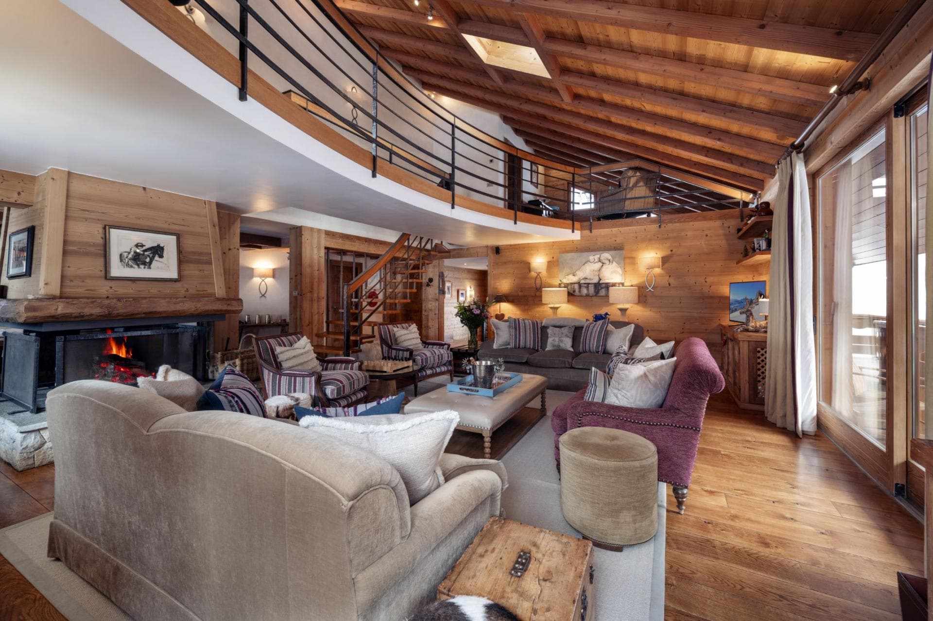 Living area with wood-burning fireplace and mezzanine balcony overlook