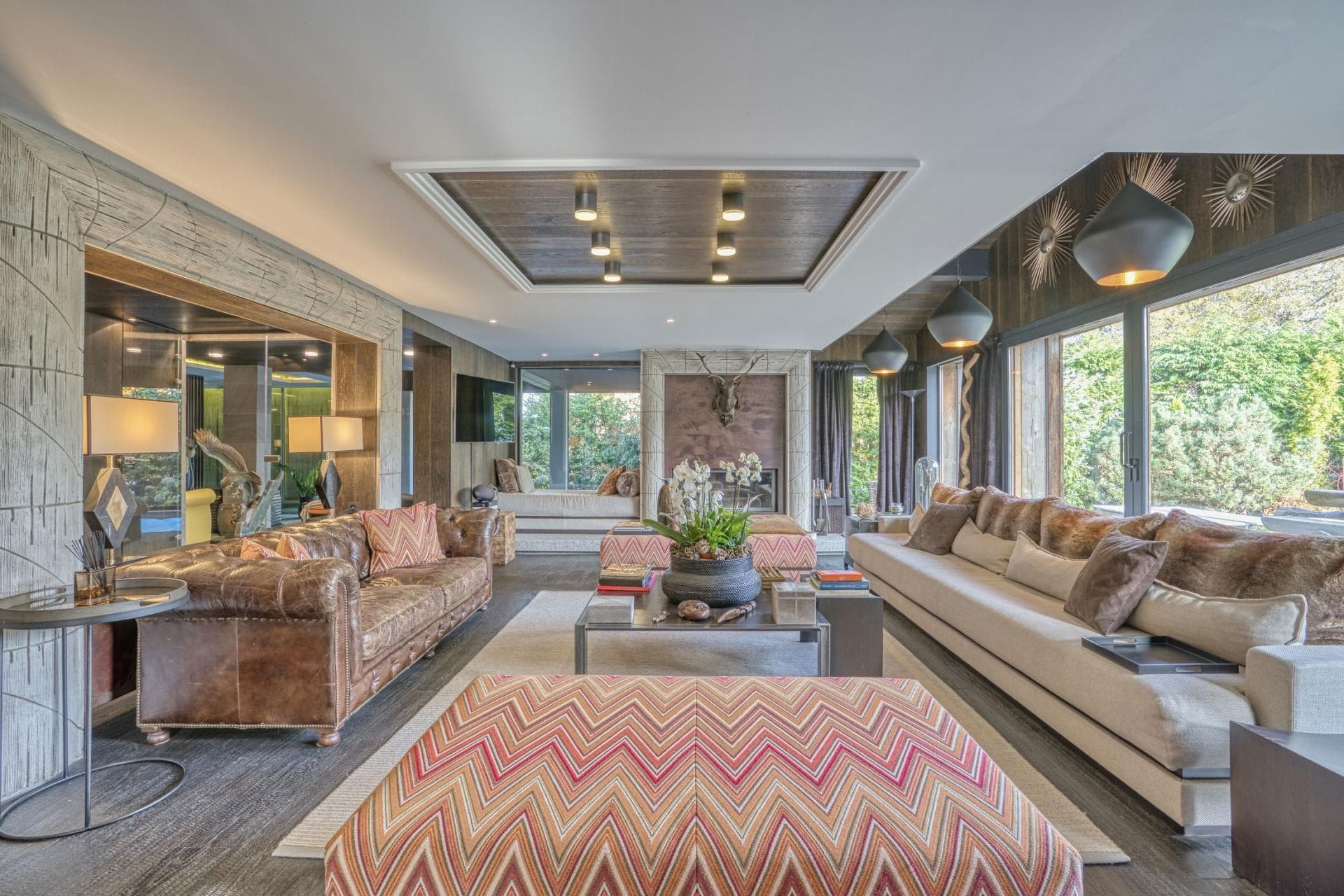 Living area with wood-burning fireplace and floor-to-ceiling windows
