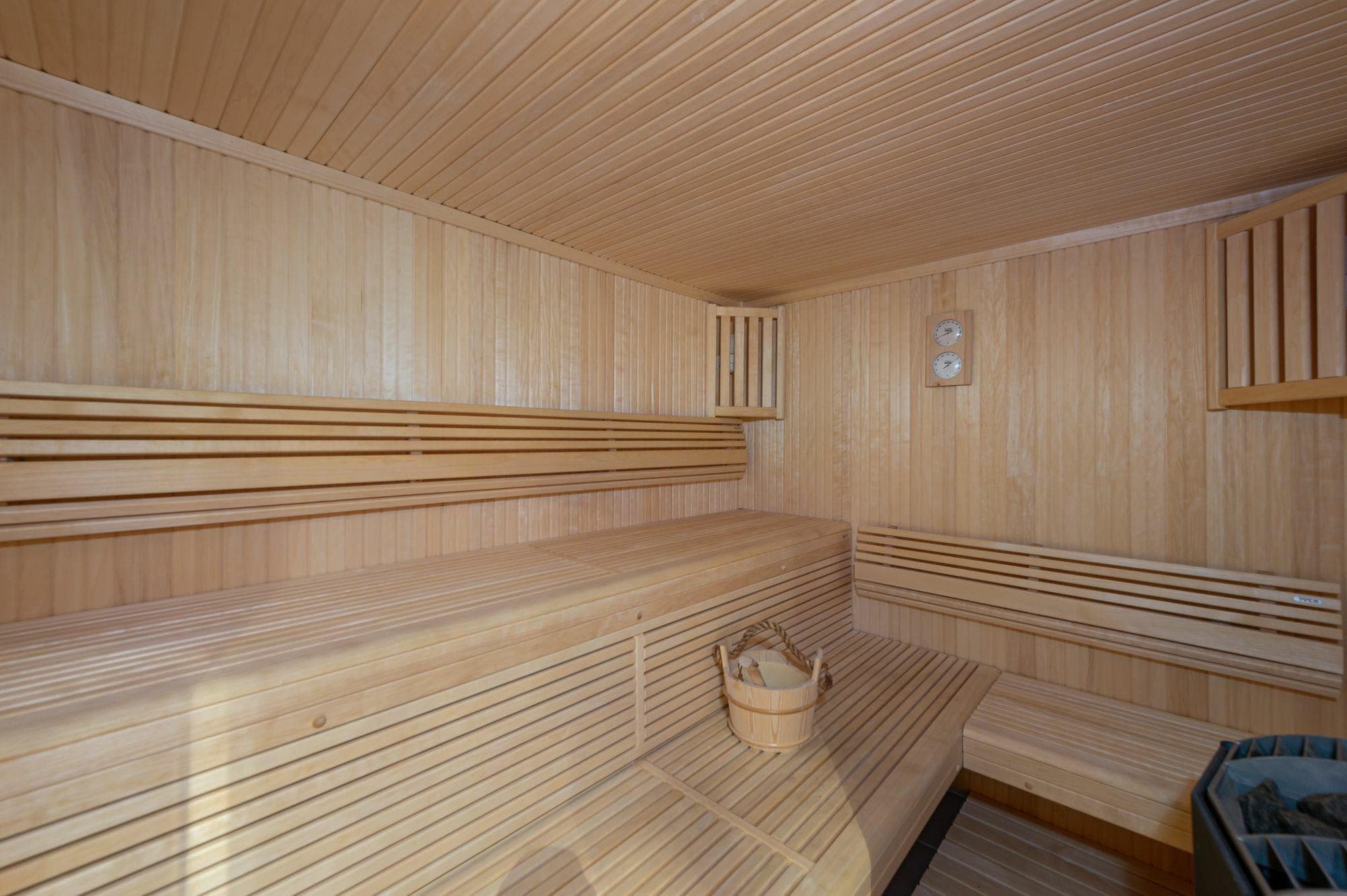 Private cedar sauna with tiered seating and electric rock heater