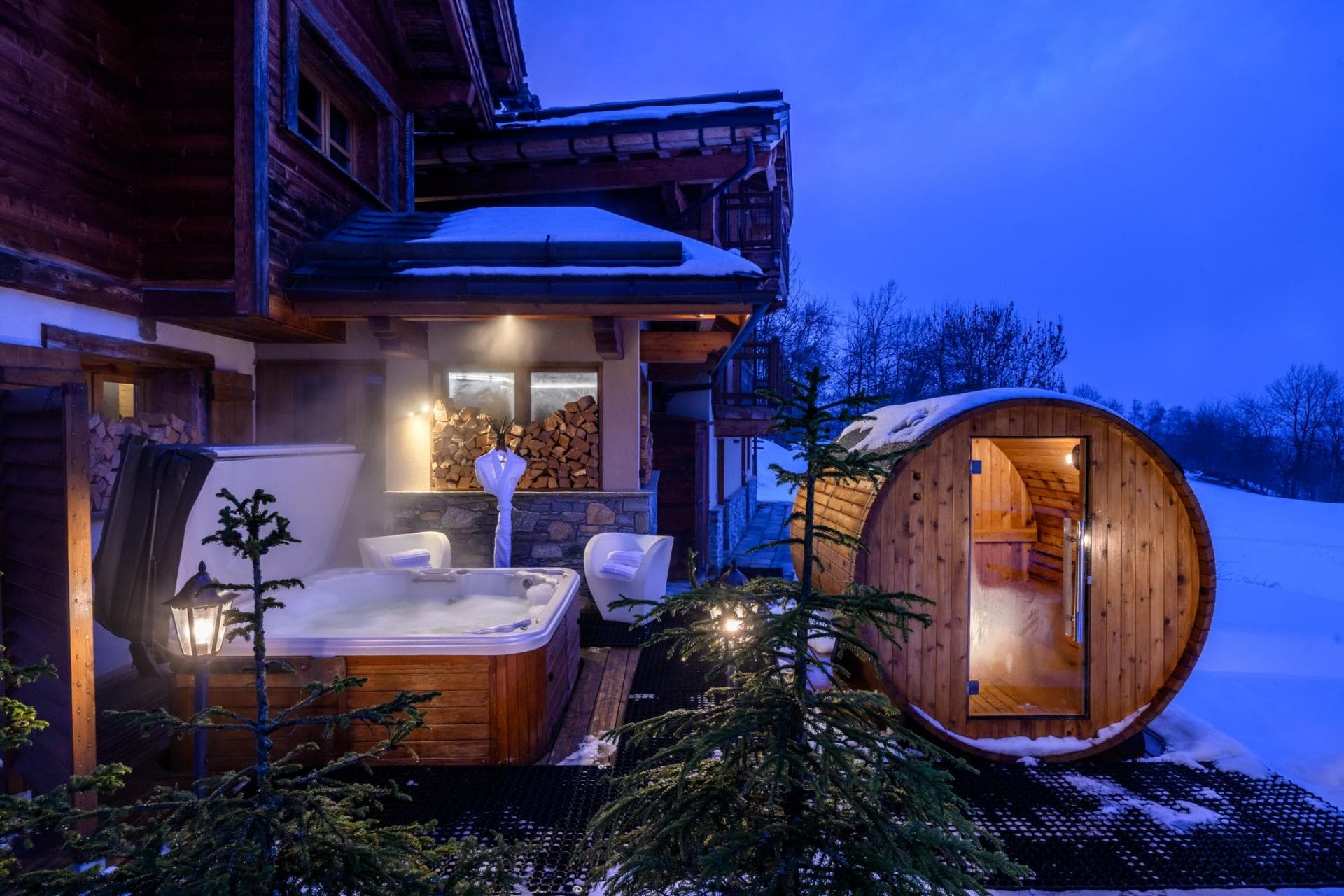 Outdoor wellness area with wood-fired barrel sauna and heated hot tub