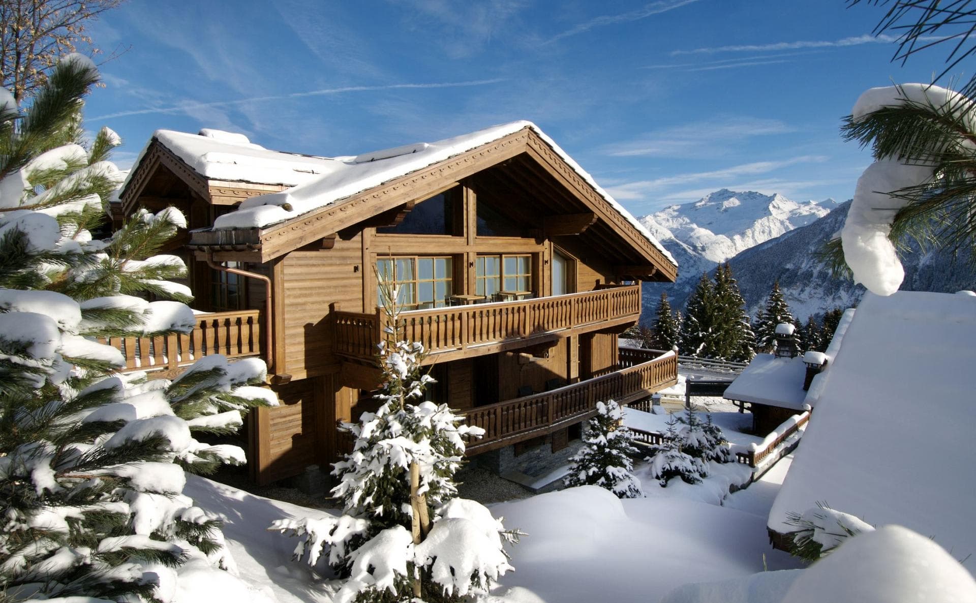 Ski-in chalet with multi-level wrap-around balconies and mountain views