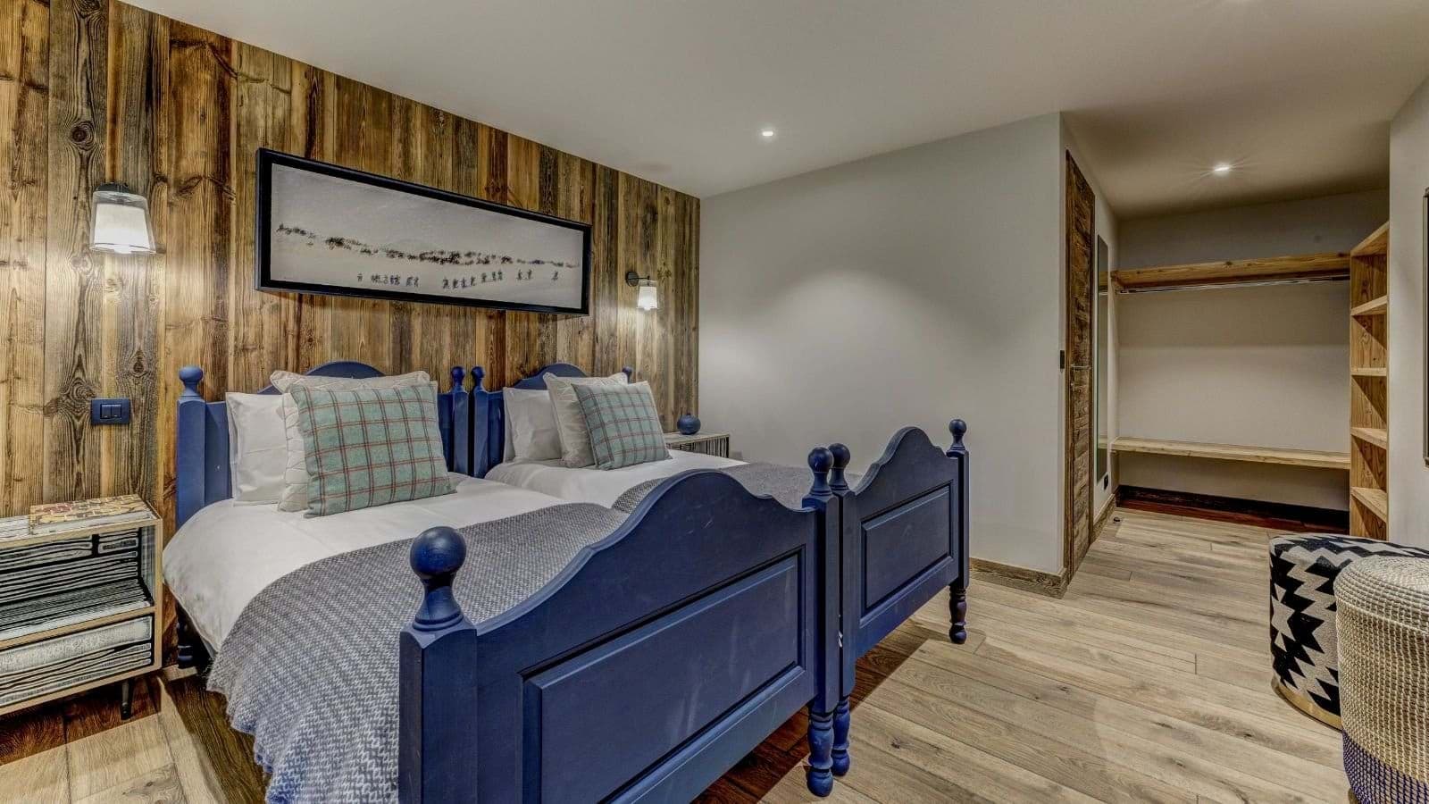 Guest bedroom with two twin beds and open-shelf walk-in closet