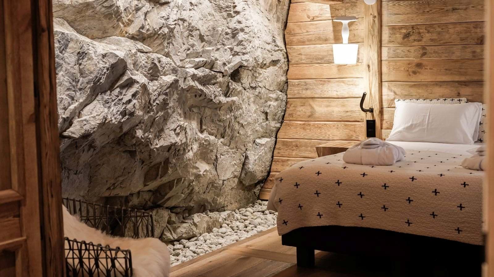 Guest bedroom with twin bed and integrated natural rock wall