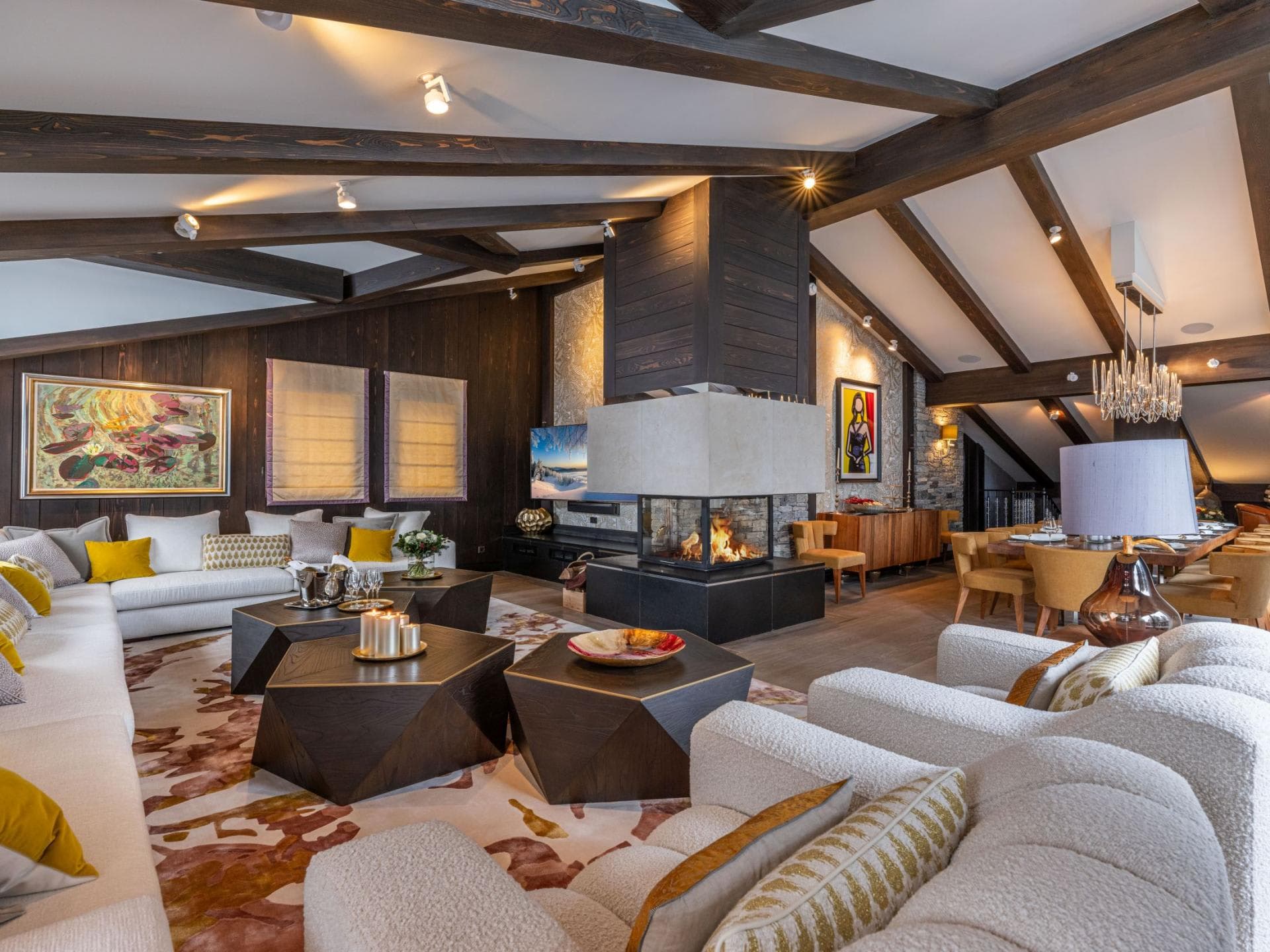 Open-plan living area with three-sided fireplace and vaulted beamed ceilings
