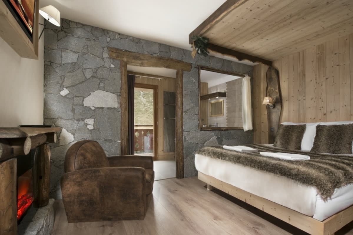 Primary bedroom featuring electric fireplace and internal window to ensuite bathroom