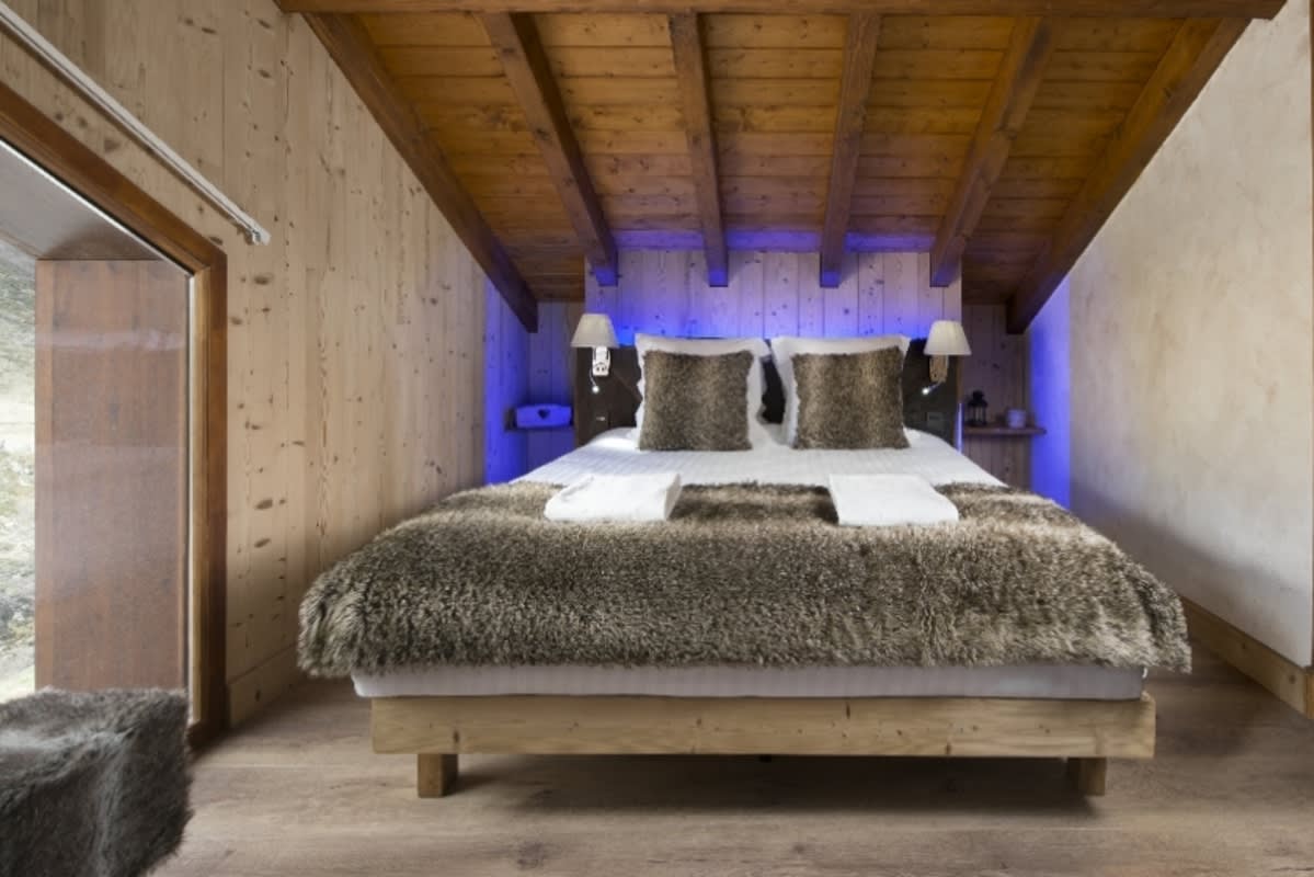 Attic bedroom with queen bed and exposed timber beams