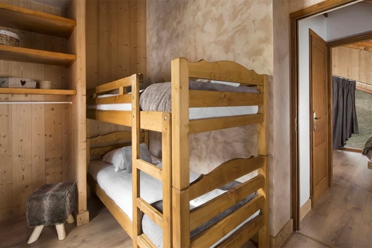 Guest bedroom with twin bunk beds and built-in closet shelving