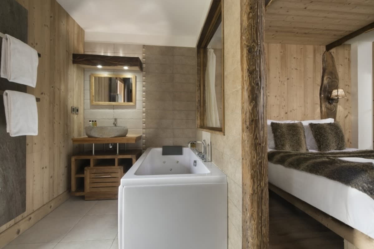 En suite bathroom with jetted soaking tub and stone basin sink