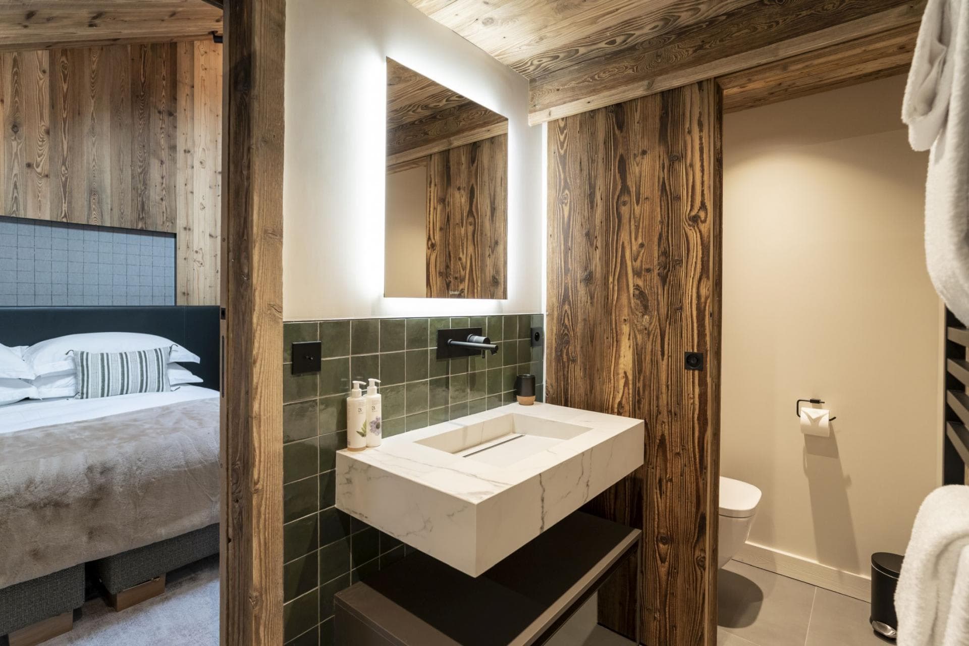 Ensuite bathroom with marble vanity and sliding reclaimed wood door