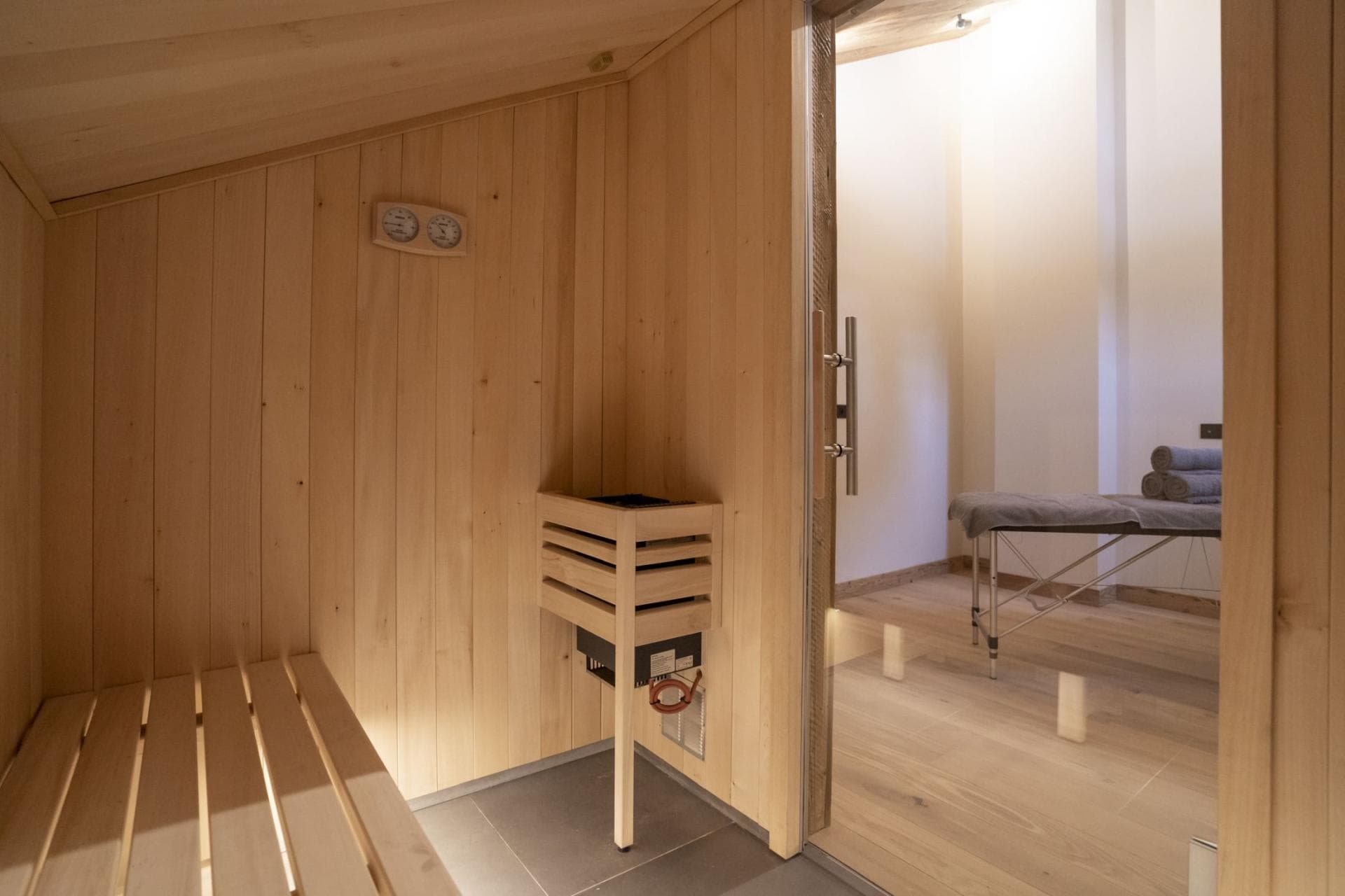 Private sauna with tiered seating and adjacent massage table