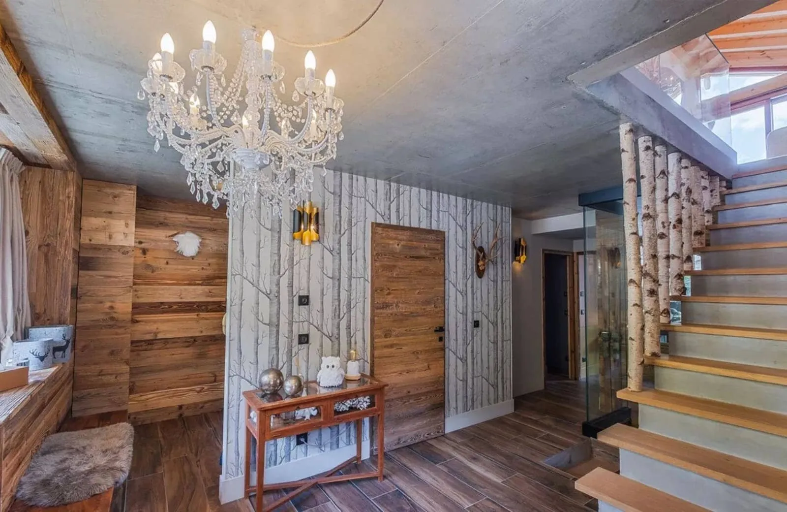 Entryway featuring birch branch staircase railing and crystal chandelier