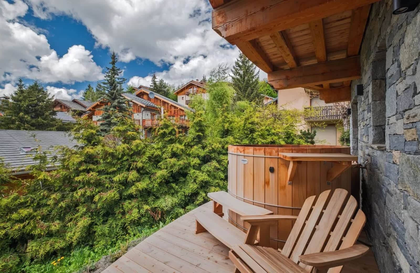 Wooden hot tub on private deck with views of neighboring chalets
