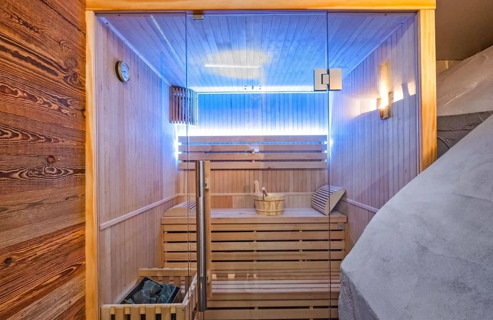 Private wooden sauna with glass door and integrated LED lighting