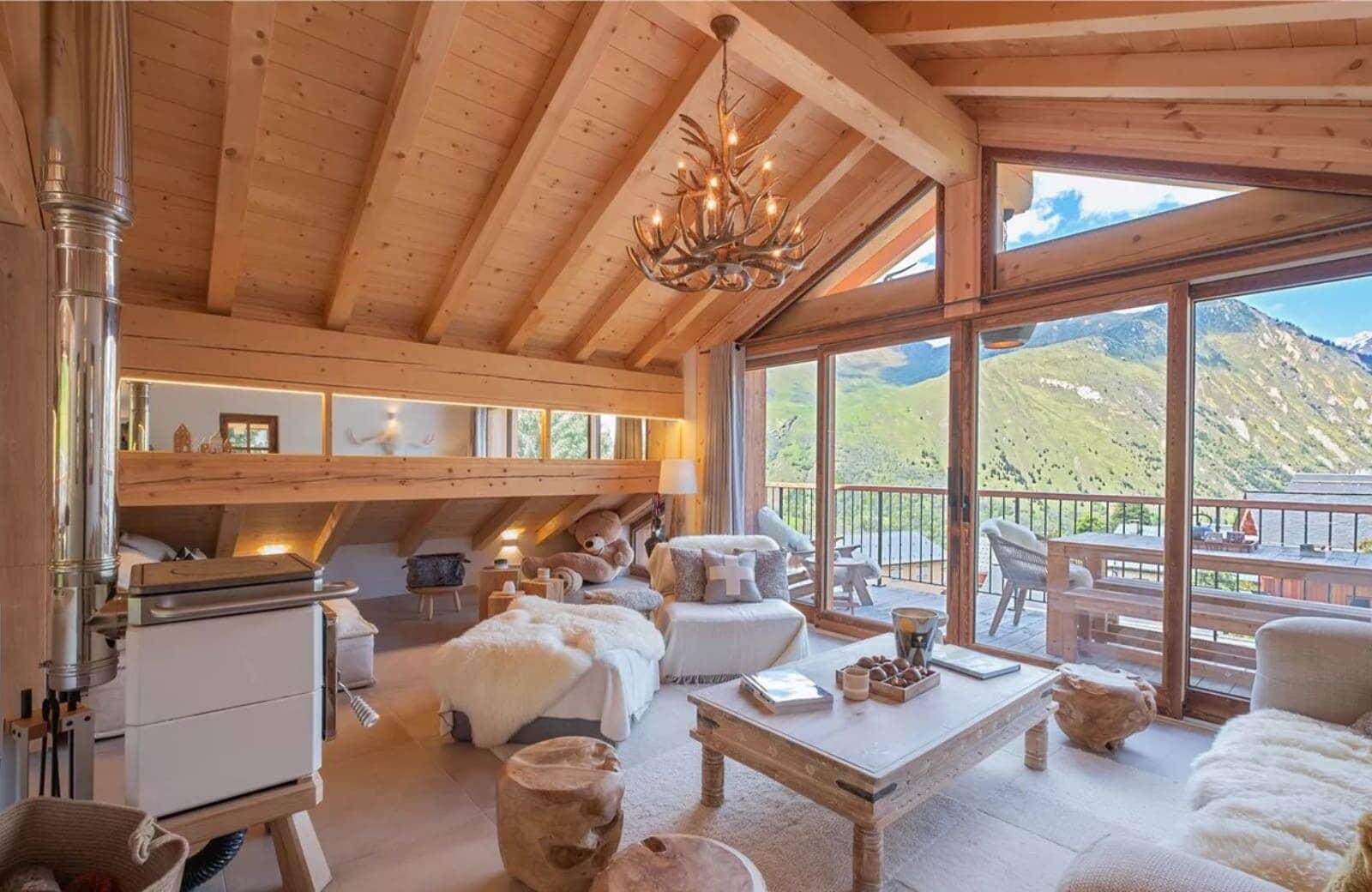 Living room with wood-burning stove and floor-to-ceiling mountain views