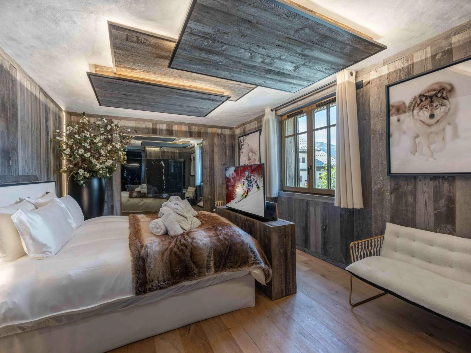 Double bedroom with timber walls and seating