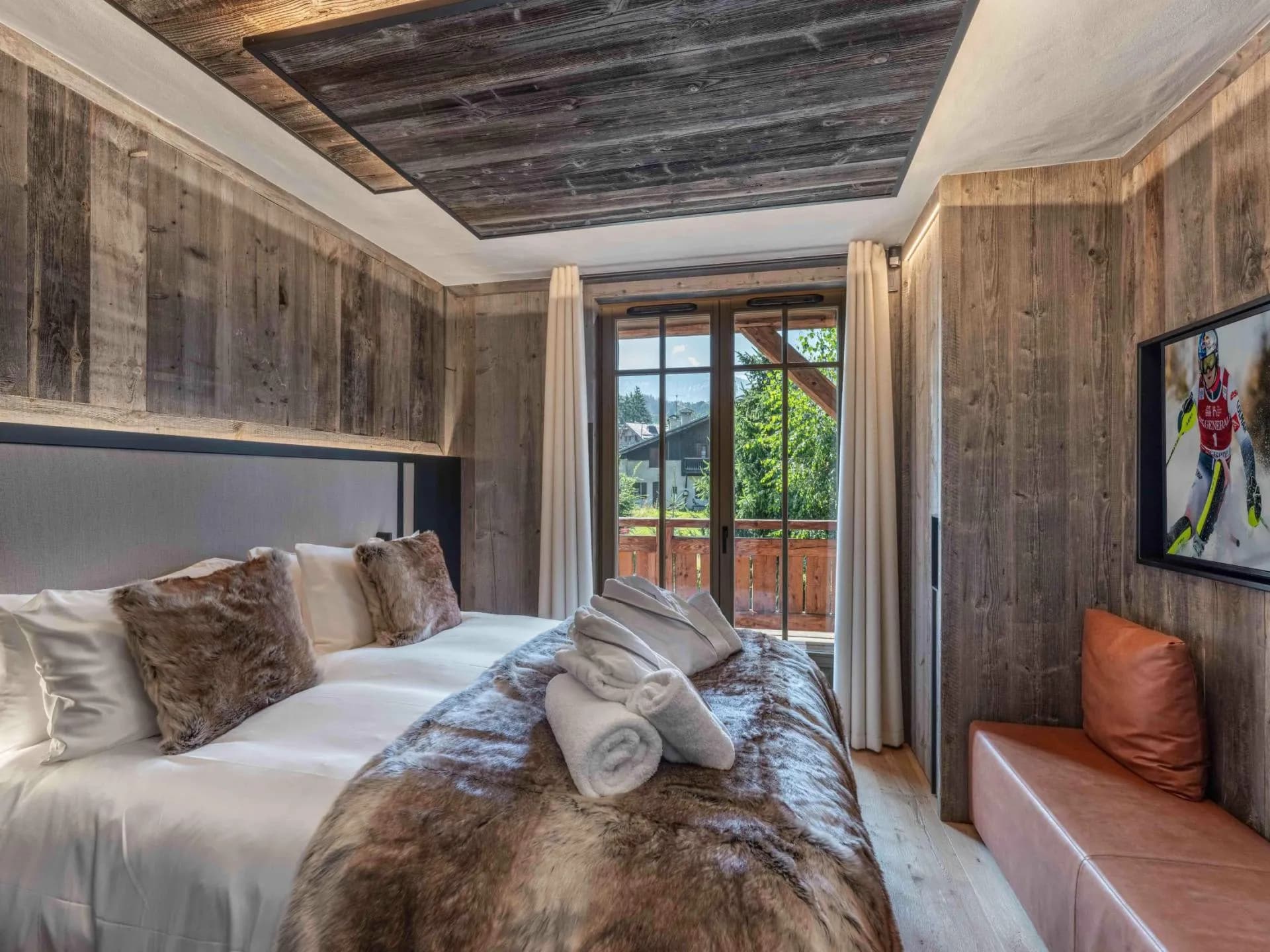 Double bedroom with timber walls and glazed doors