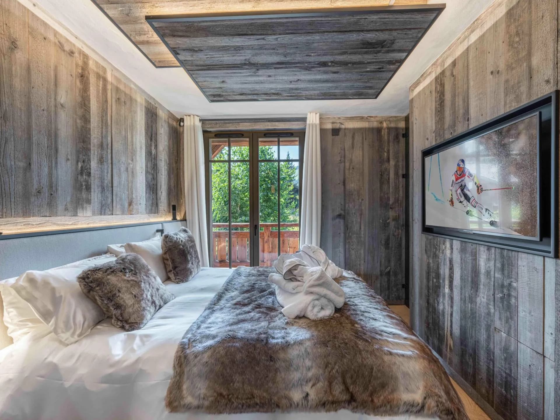 Double bedroom with television and glazed doors