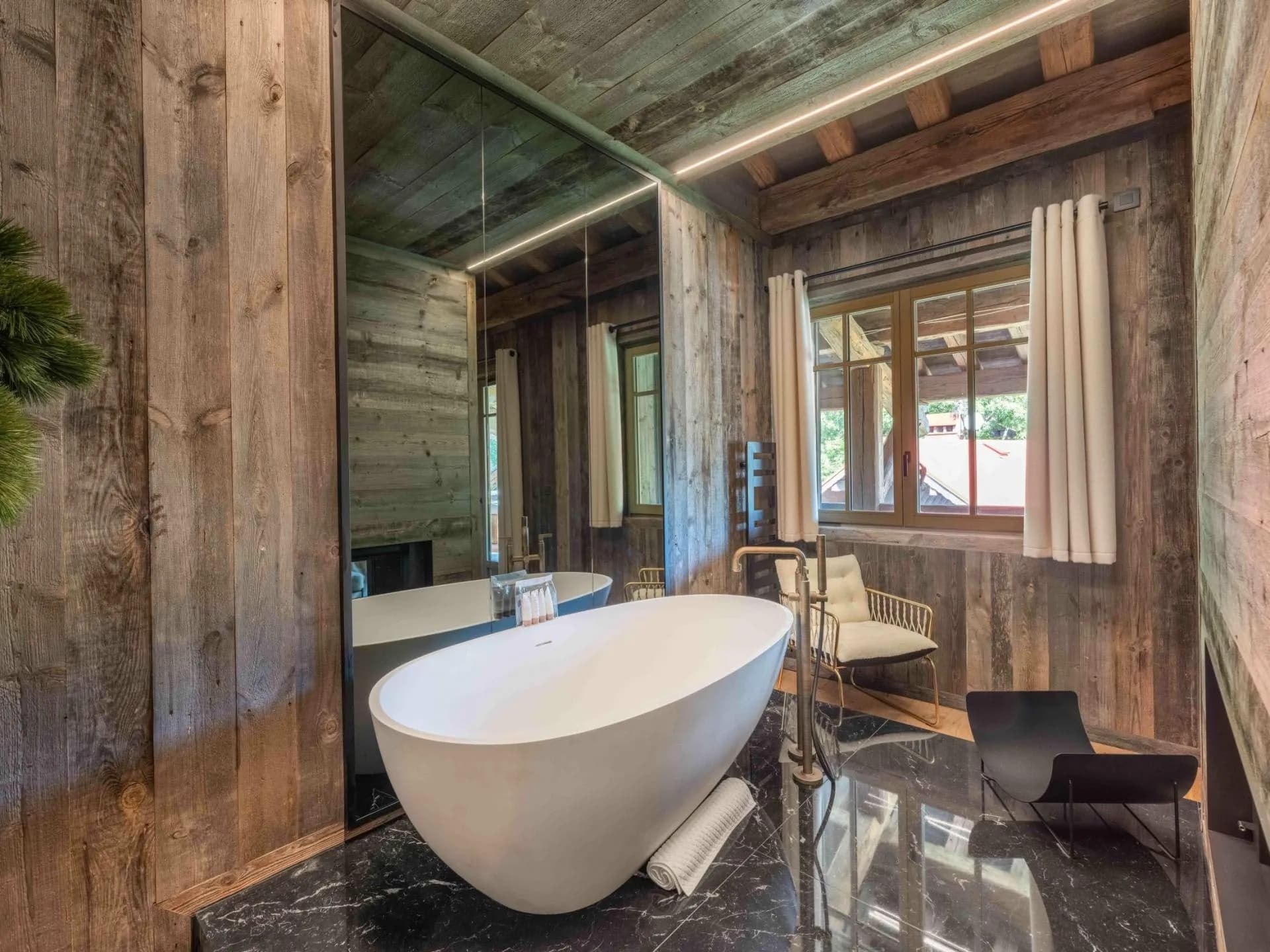 Freestanding bath beside large windows