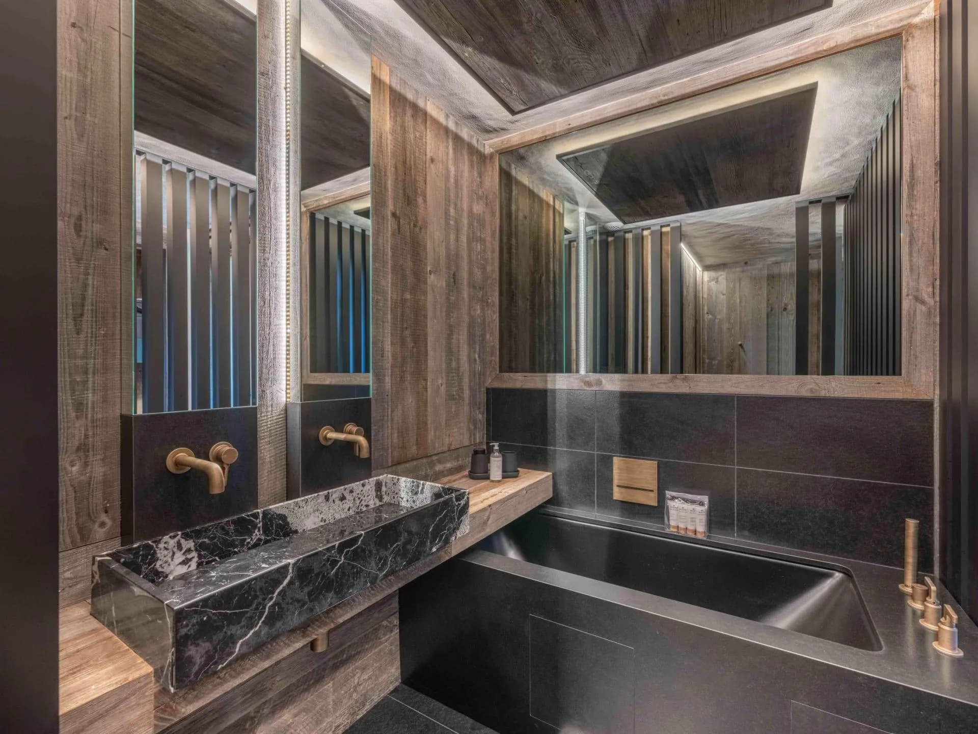 Bathroom with dark stone finishes, bathtub and vanity