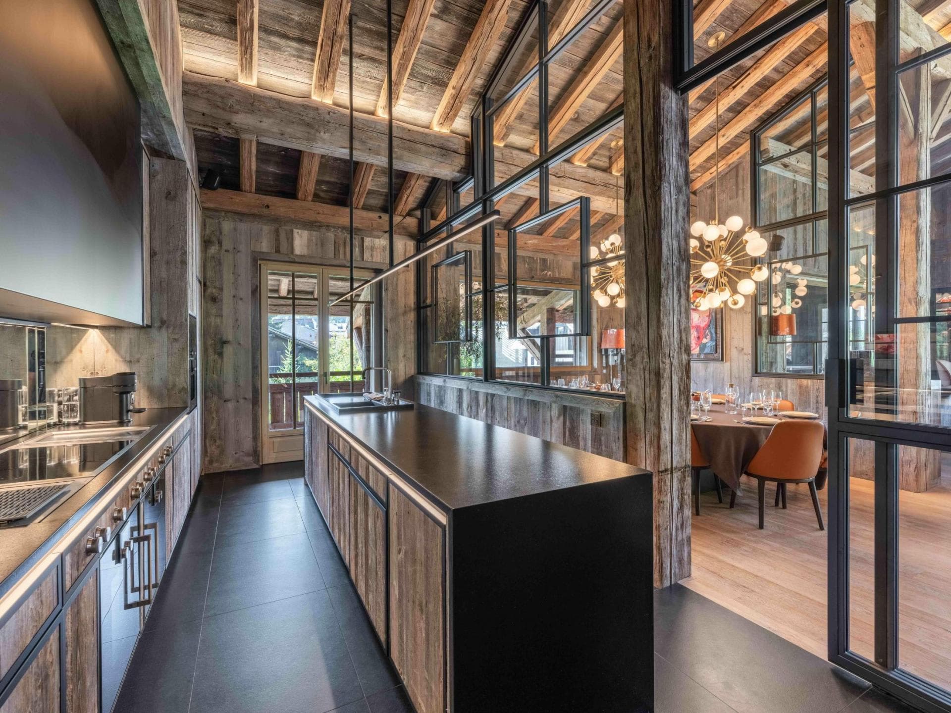 Kitchen with large prep island and glass partition to dining area