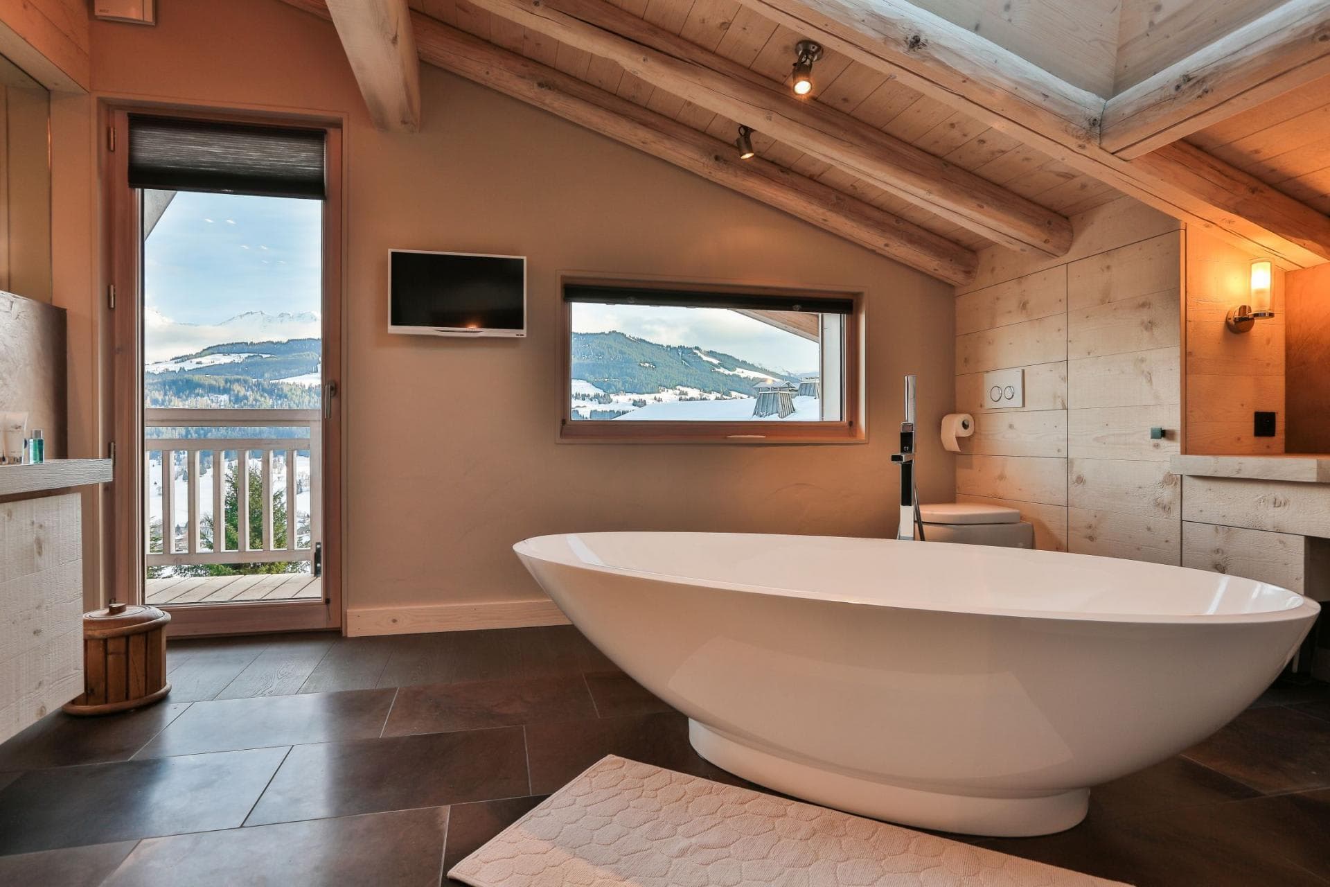 Bathroom with freestanding soaking tub and mountain-view balcony access