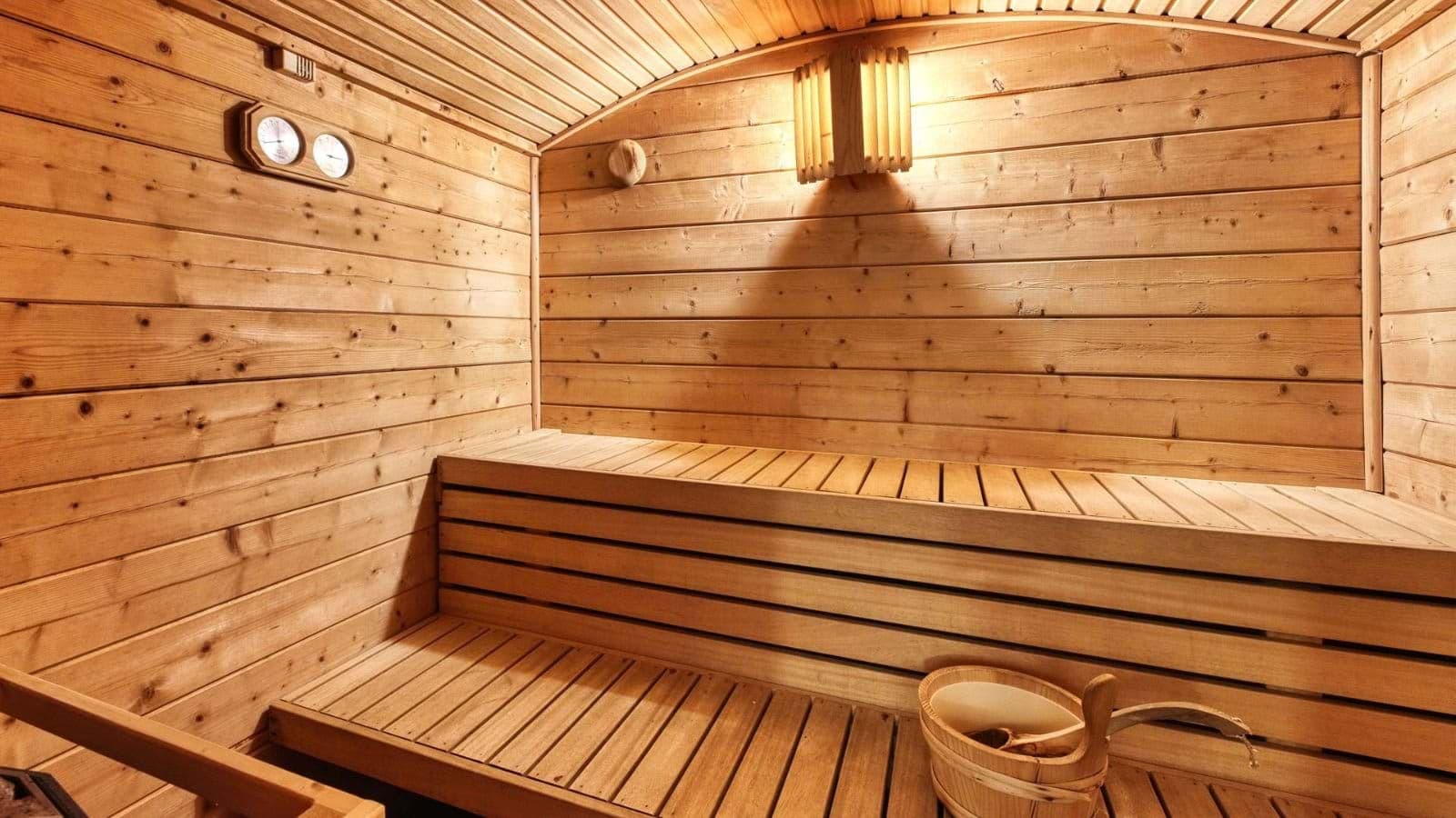 Private cedar sauna with tiered seating and traditional bucket