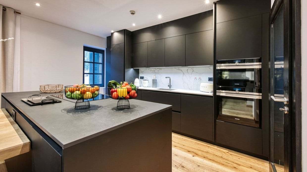 Kitchen with waterfall island, induction cooktop, and double wall ovens