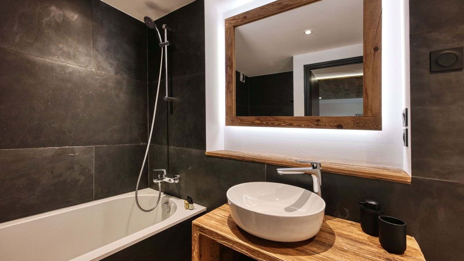 Bathroom featuring vessel sink and soaking tub with handheld shower head