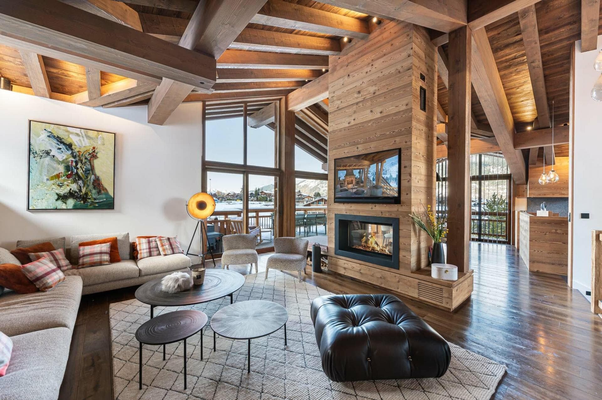 Living area with wood-burning fireplace and floor-to-ceiling windows to balcony