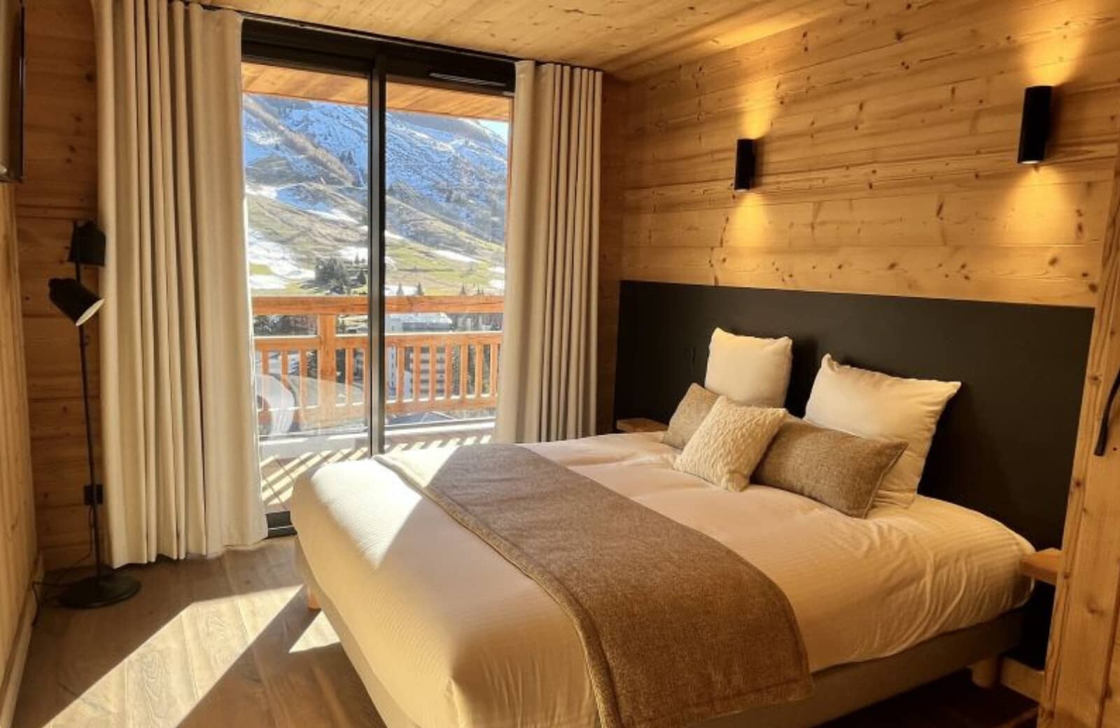 Bedroom with king bed and sliding door access to mountain-view balcony