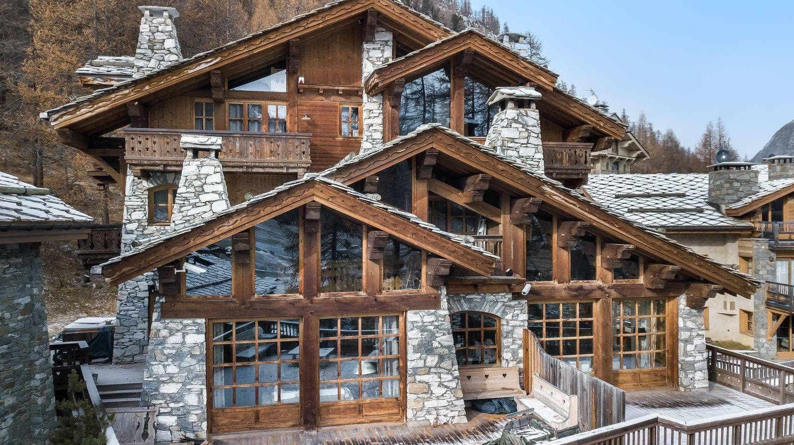 Timber and stone chalet exterior featuring multiple private balconies